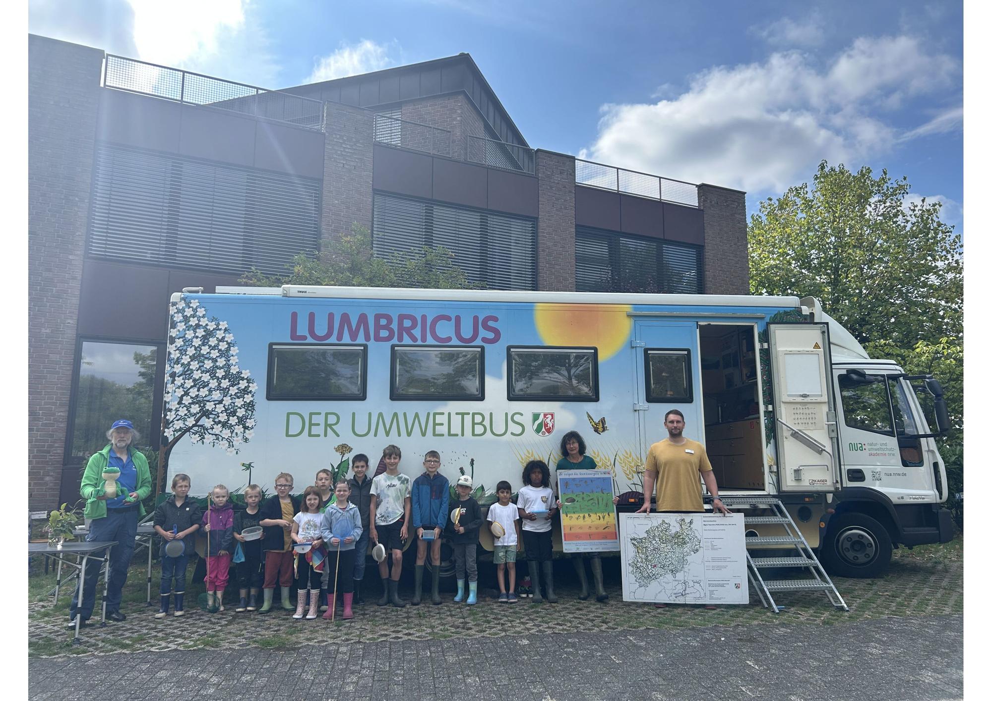 Die Umweltpädagogen Regina von Oldenburg und Matthias Nisbach (rechts) mit einigen der teilnehmenden Kinder vor dem Umweltbus „Lumbricus“.