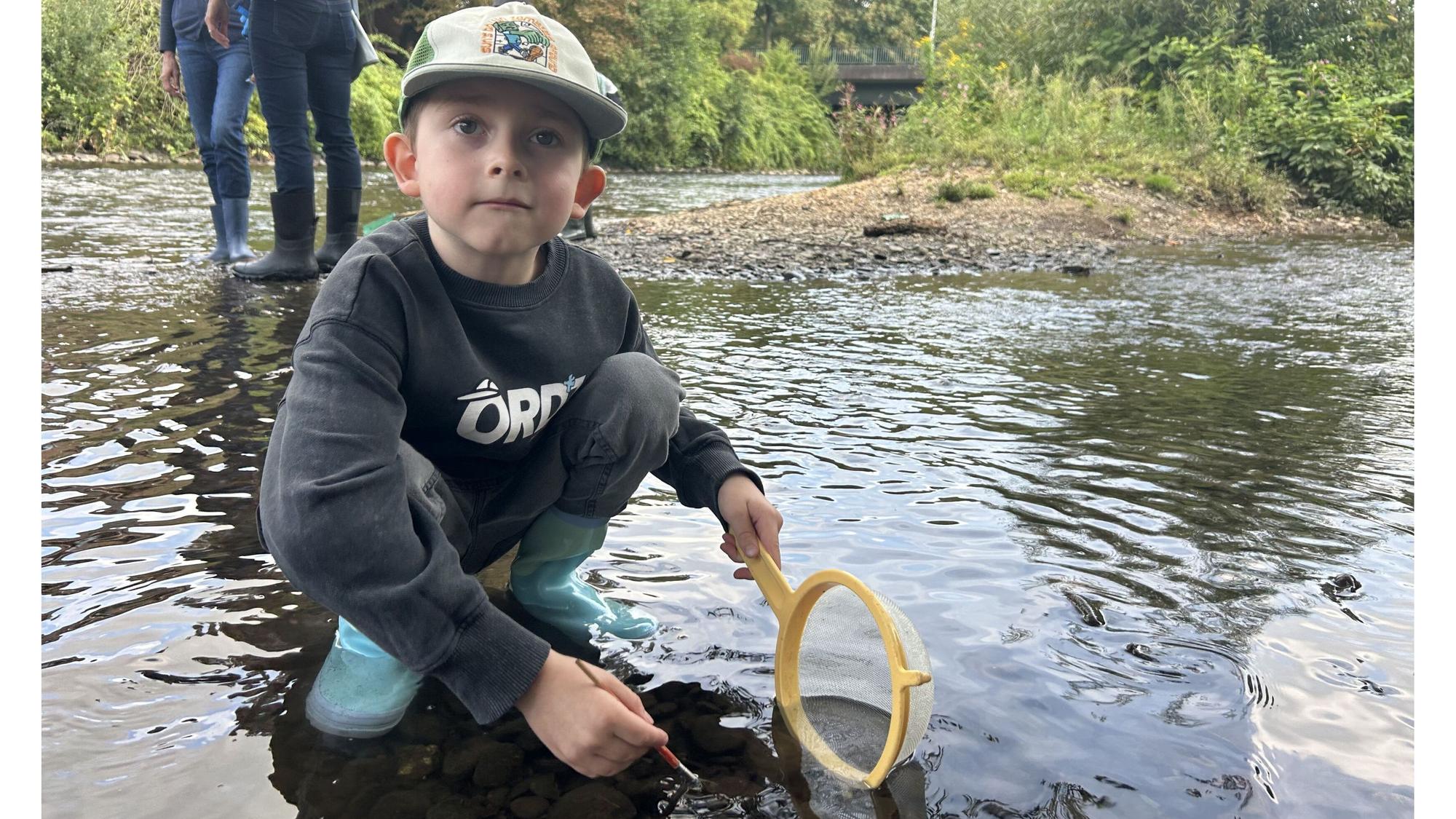 Mit Kescher und Gummistiefeln sucht Moritz (6) in der Wupper nach kleinen Wasserbewohnern.