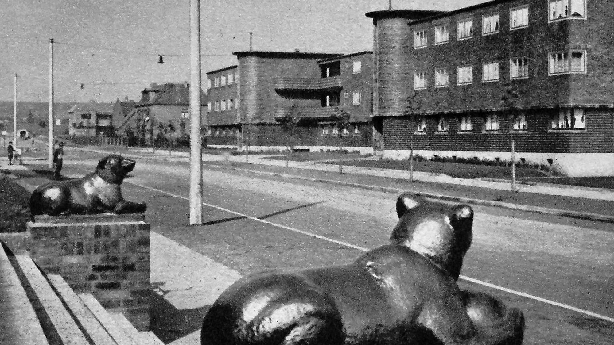 Die historische Aufnahme des Freiheitsrings entstand um 1930, die keramischen Bärenfiguren an den Hauseingängen werden den Bildhauern Franz Albermann und Peter Berens zugeschrieben.