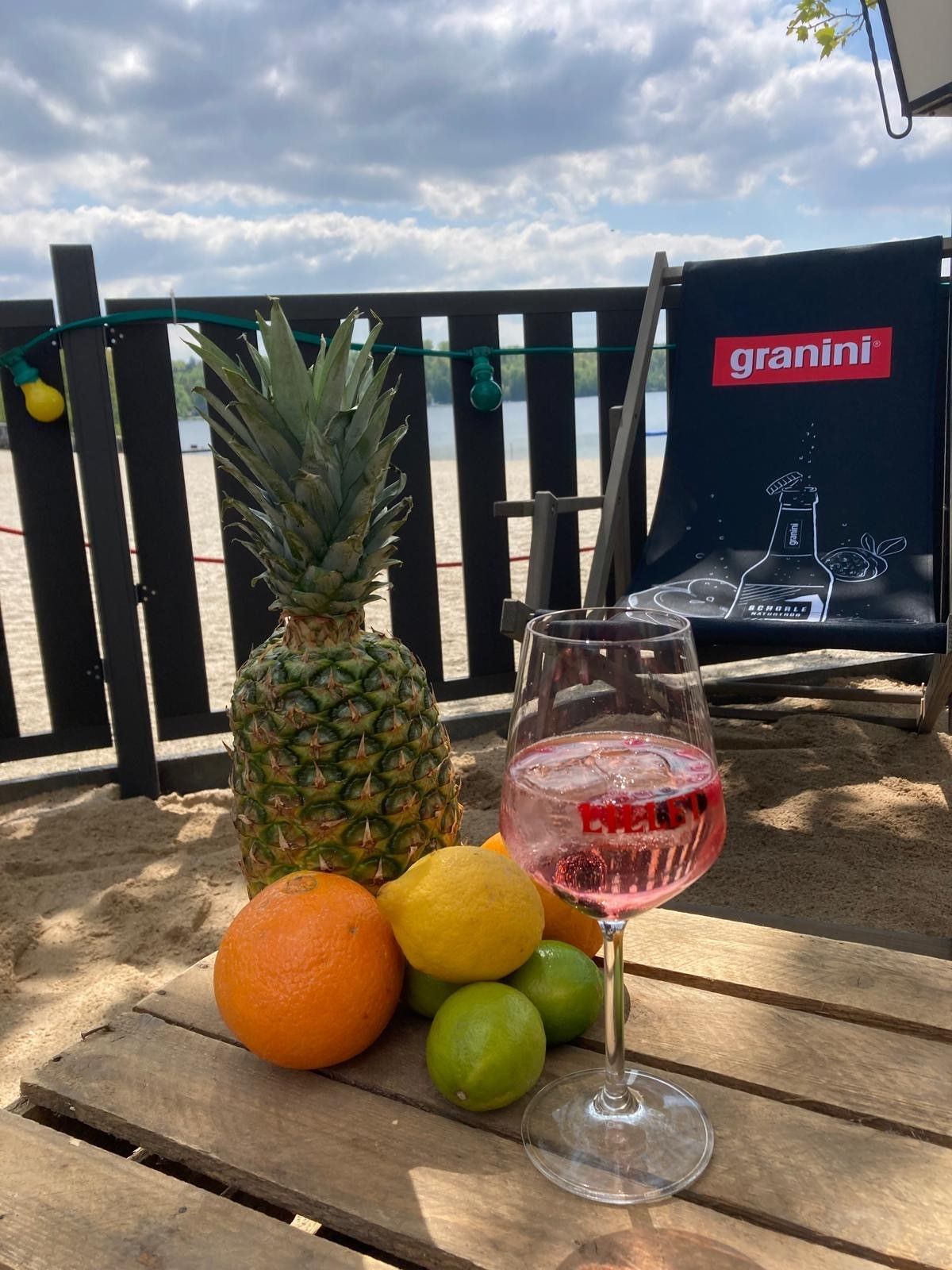 Auf dem Bild sind ein gefülltes Weinglas und Obst zu sehen.