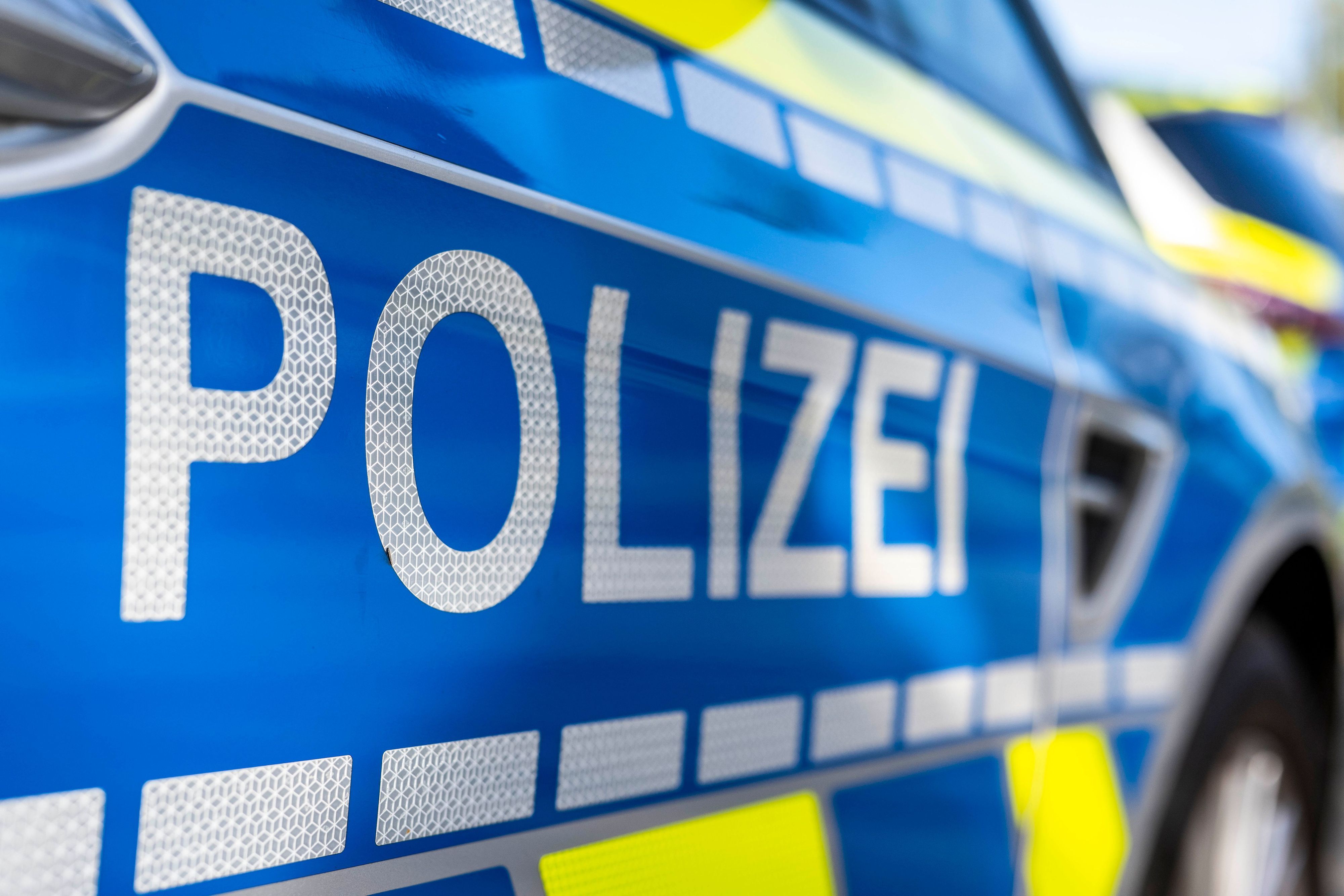 An der Tür von einem Streifenwagen steht der Schriftzug „Polizei“.