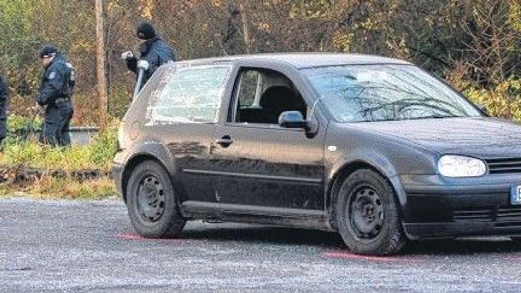 Das Bild zeigt Polizeibeamte an einen Auto.