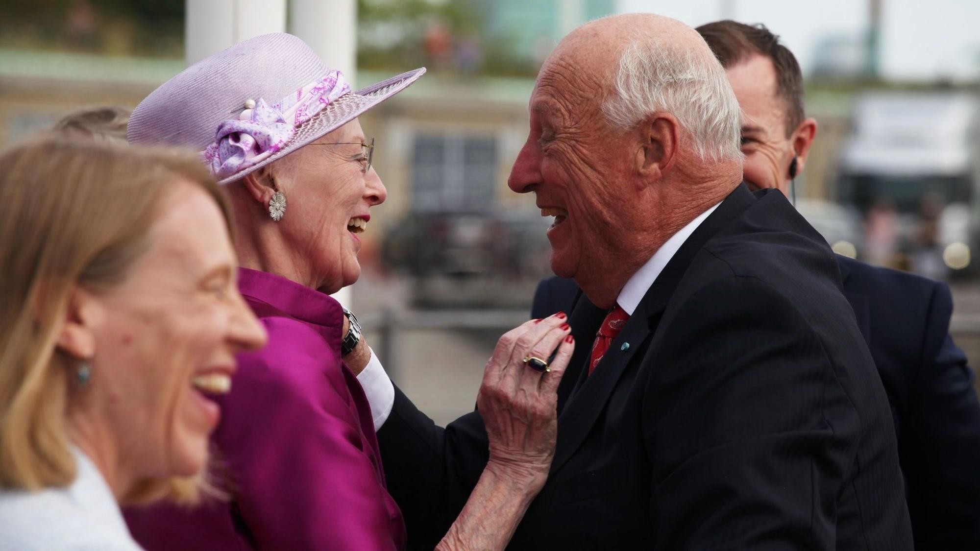 Königin Margrethe und König Harald V. lachen miteinander.