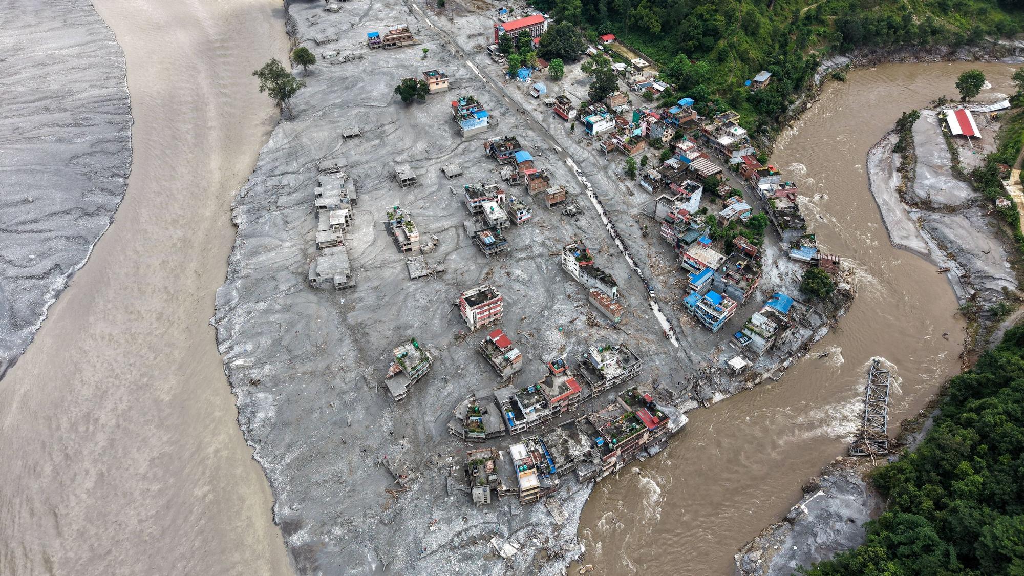 Ein Luftbild zeigt Häuser in einer Stadt am Trishuli-Fluss, die durch die Sturzfluten zerstört wurden