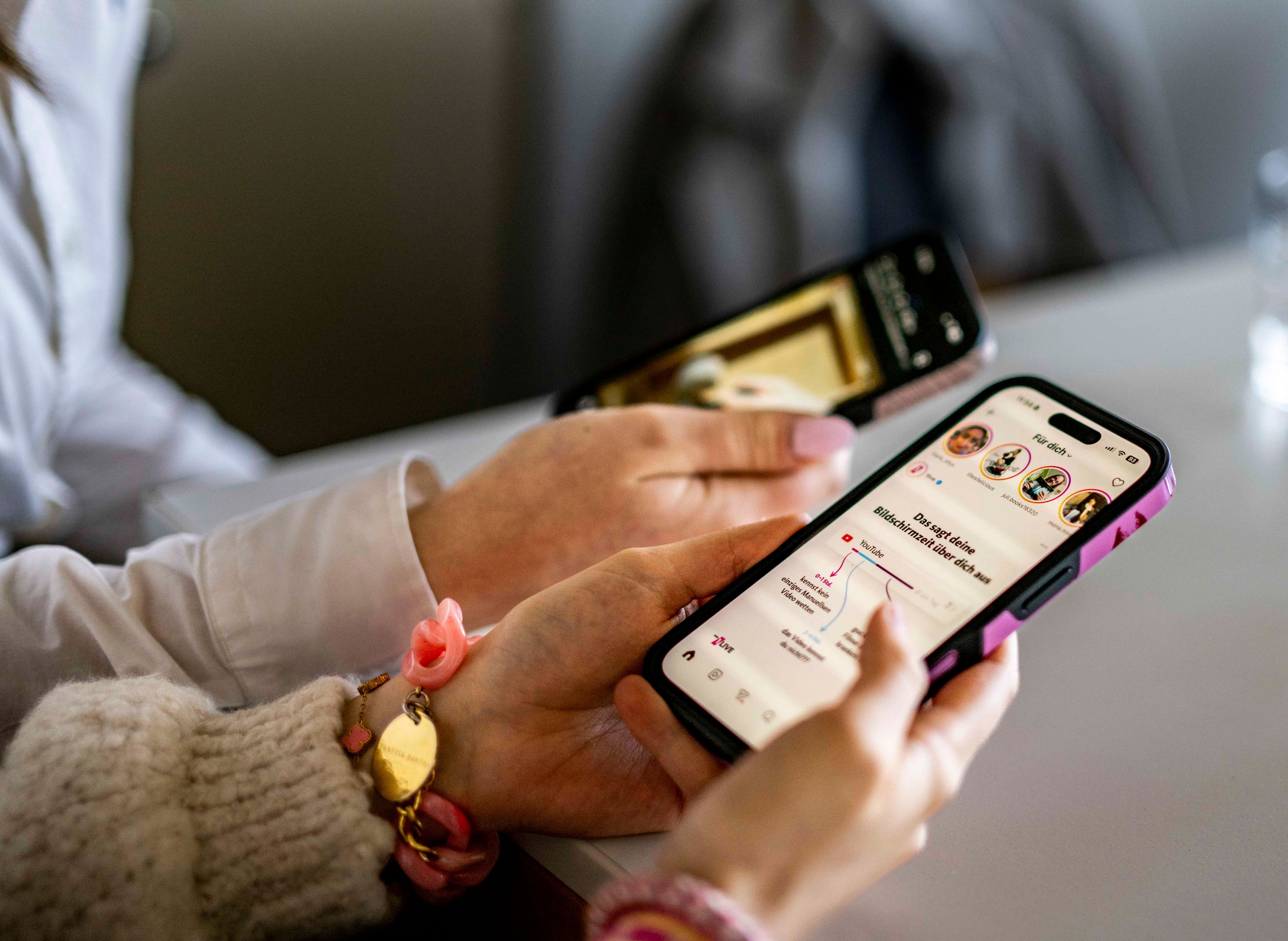 Das Symbolbild zeigt zwei Smartphones in den Händen ihrer Nutzerinnen.