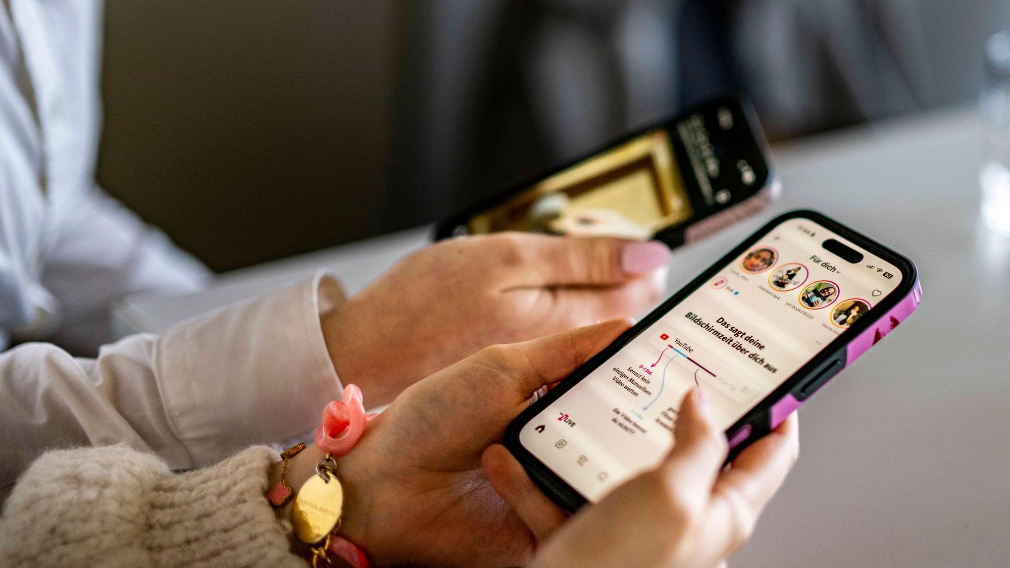 Das Symbolbild zeigt zwei Smartphones in den Händen ihrer Nutzerinnen.