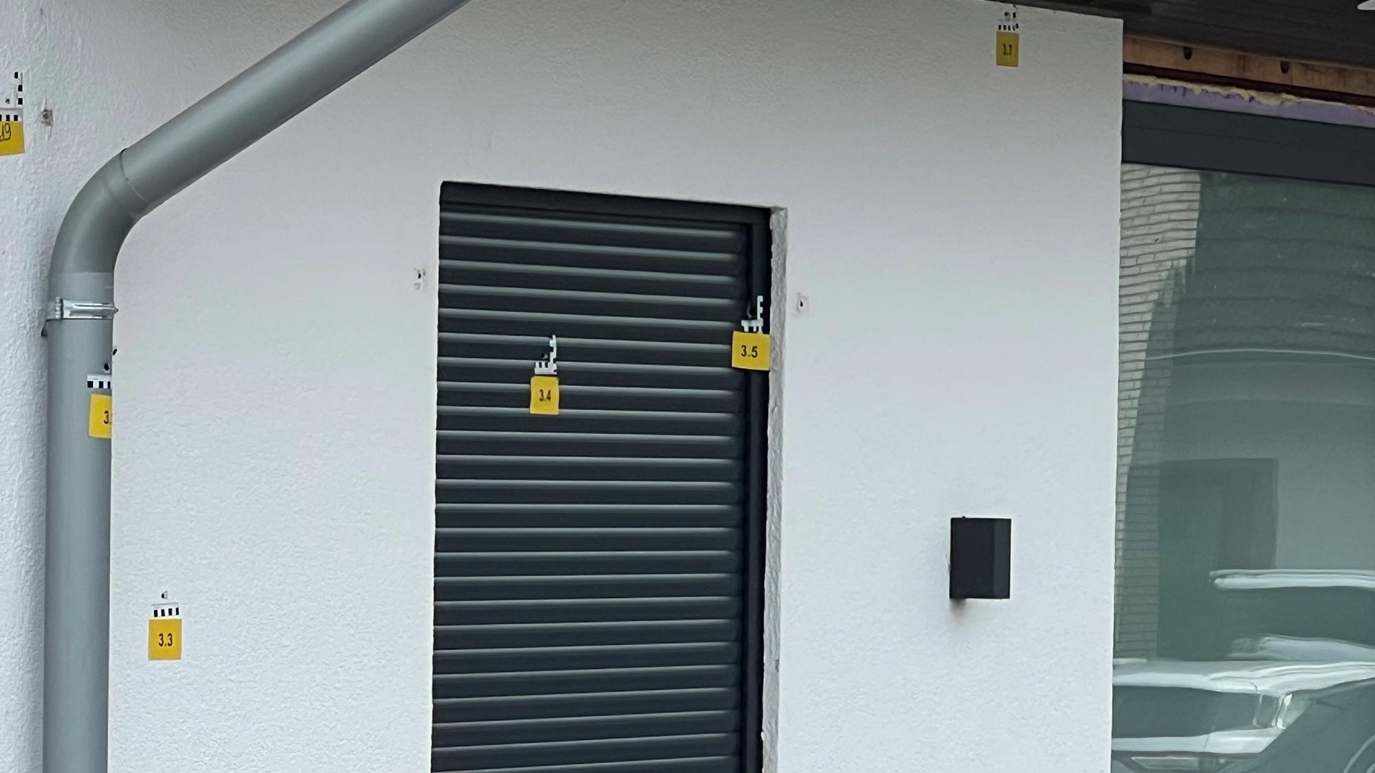 Das Foto zeigt eine Fassade mit durchnummerierten Markierungen an den Einschusslöchern.