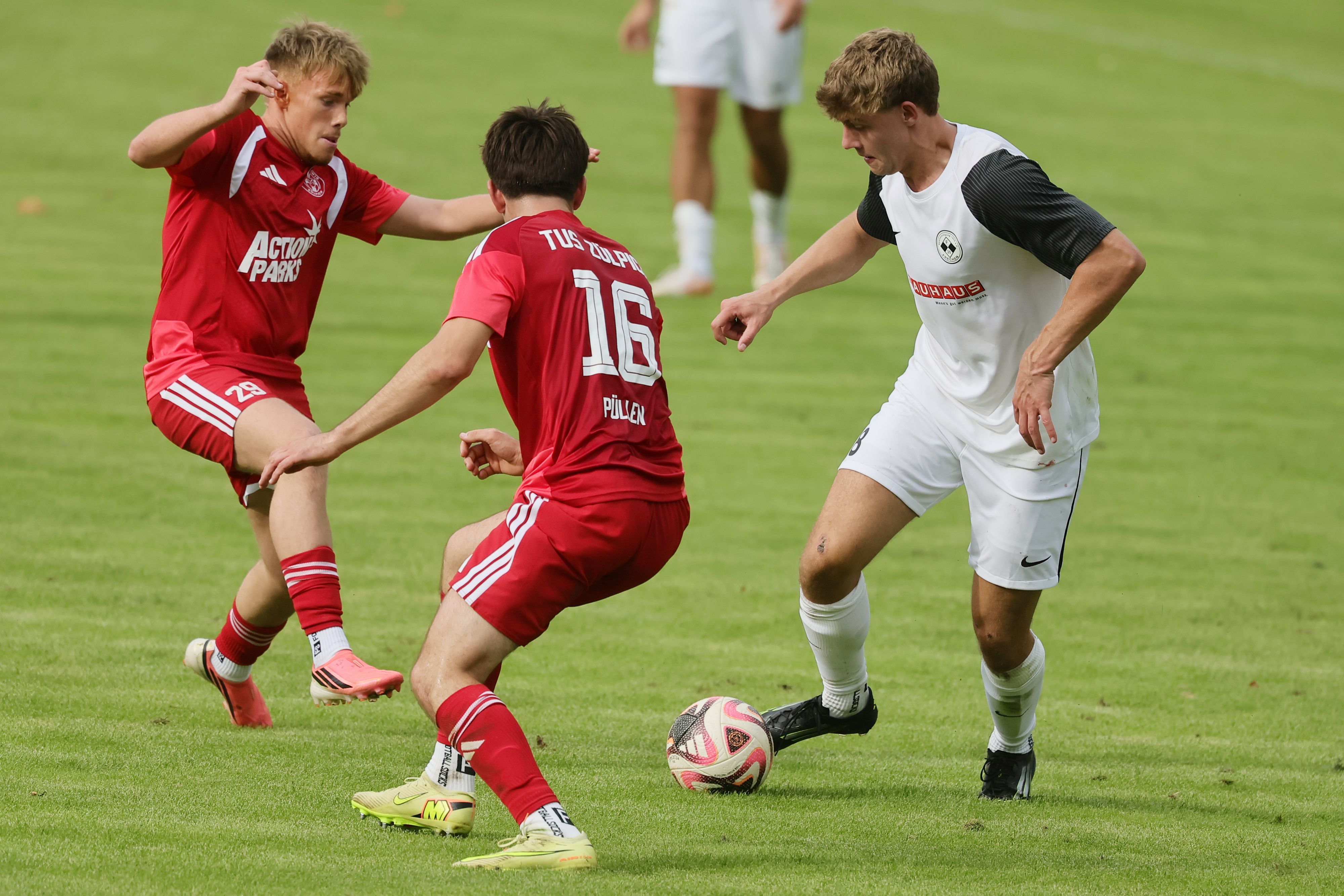 Das Foto zeigt den Fußballer der Zwanziger Simon Reetz (r.), der den Zweikampf mit gleich zwei Gegenspielern sucht.
