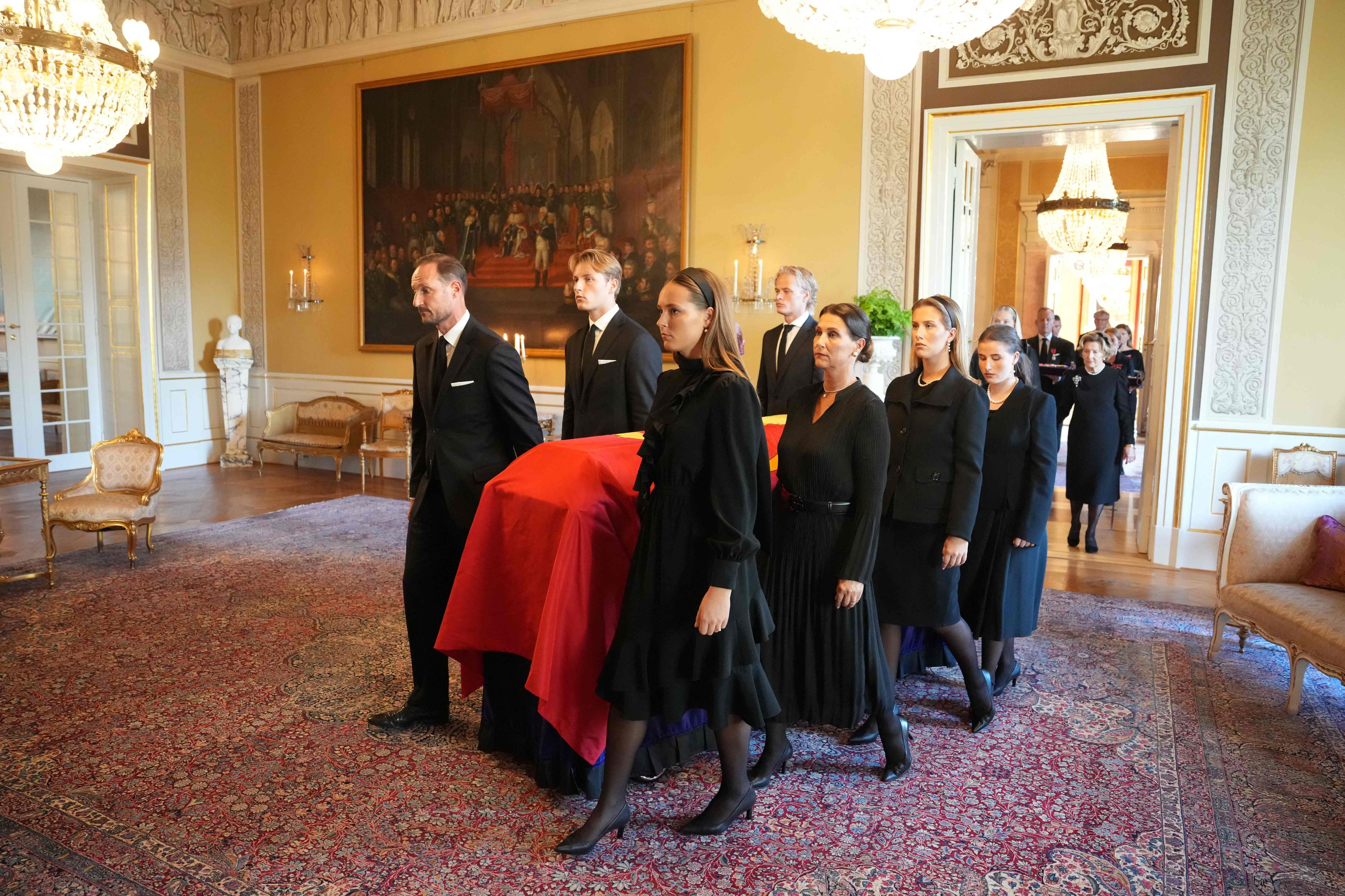 Der Sarg von König Harald V. von Norwegen wird am 31. August 2026 von Mitgliedern der königlichen Familie aus dem Roten Salon in die Schlosskapelle in Oslo überführt: Die Kinder, König Haakon VIII. von Norwegen (l.), Prinzessin Märtha Louise von Norwegen, die Enkelkinder Kronprinzessin Ingrid Alexandra (vorne r.), Prinz Sverre Magnus von Norwegen, der Sohn von Königin Mette-Marit von Norwegen, Marius Borg Høiby, Maud Angelica Behn, Leah Isadora Behn und Emma Tallulah Behn im Spiegelsaal, gefolgt von Königin Mette-Marit von Norwegen und Königin Sonja von Norwegen.