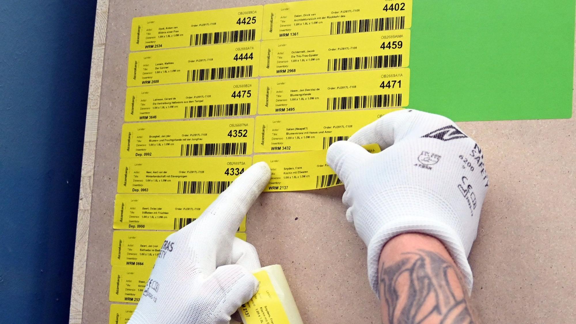 An den Kisten werden die Barcodes für die Bilder angebracht.