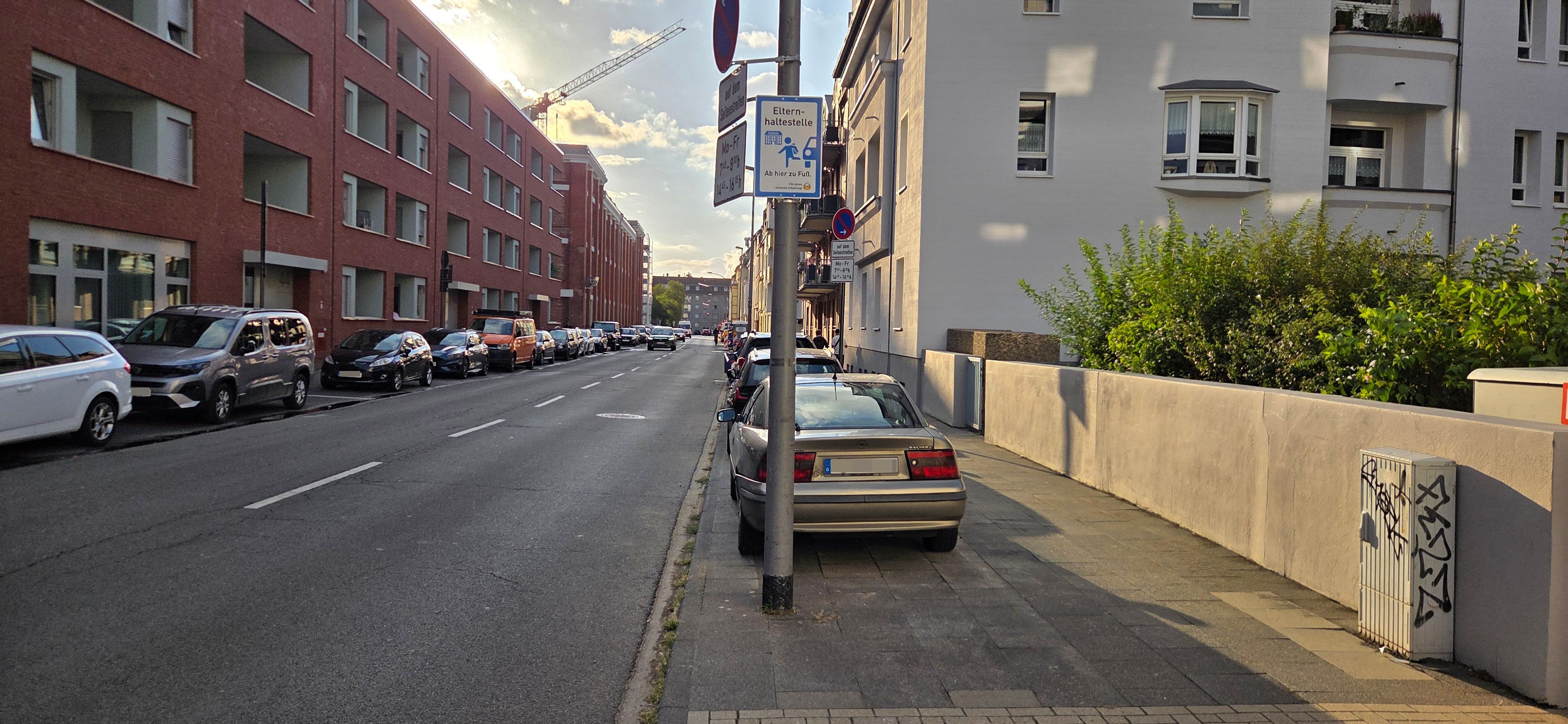 Die Stadt Köln hat wie hier an der Xantener Straße in Nippes an drei Schulen Elternhaltestellen eingerichtet und dafür Hinweisschilder aufgestellt.