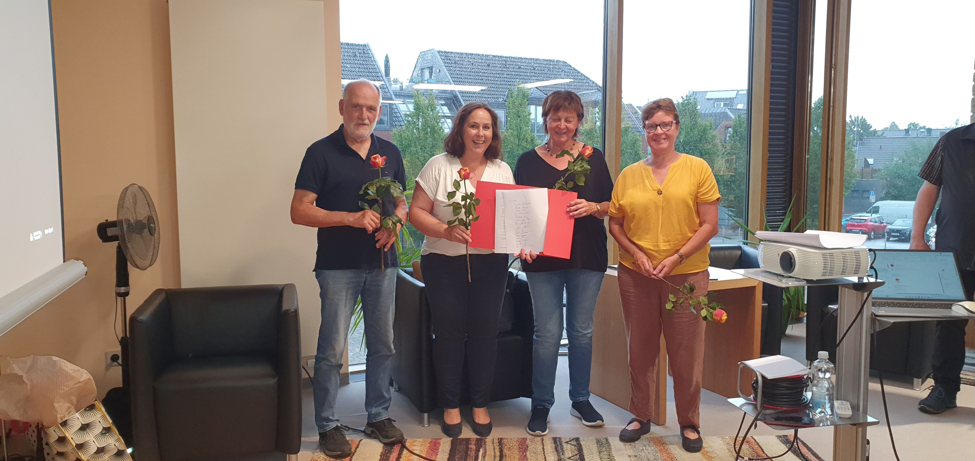 Drei Frauen und ein Mann lächeln in die Kamera.