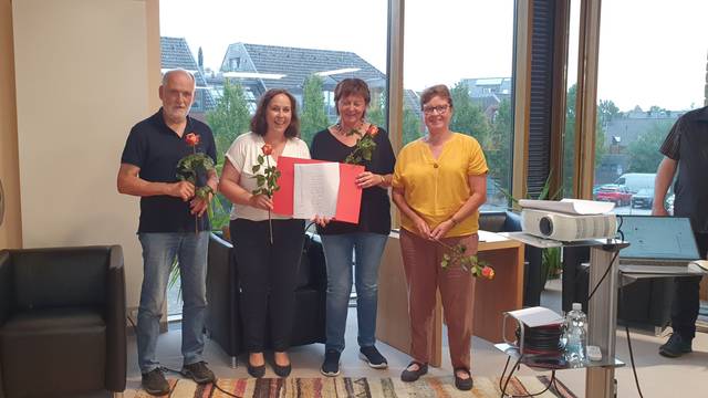 Drei Frauen und ein Mann lächeln in die Kamera.