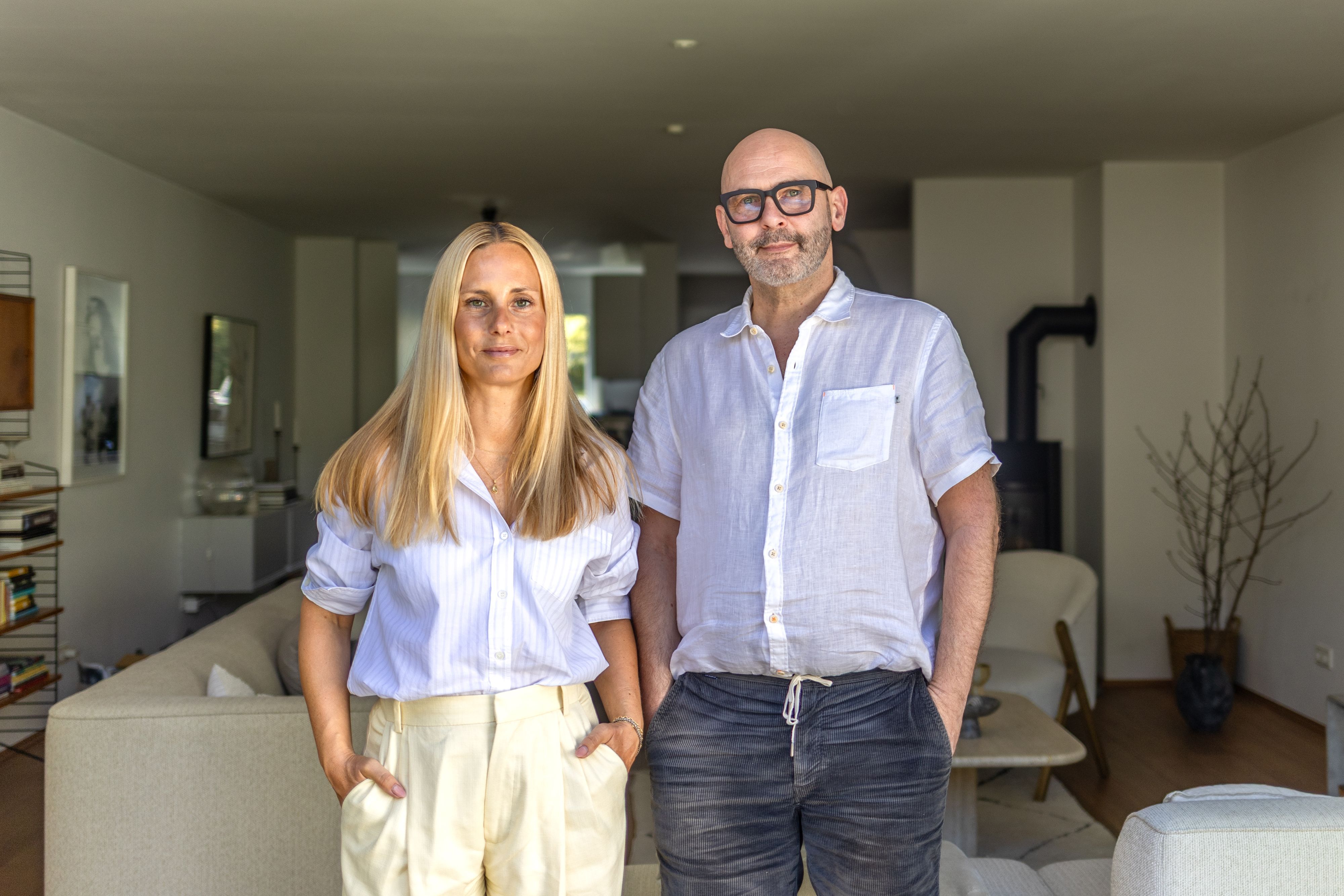 Ein Mann und eine Frau, beide in weißen Blusen, schauen in die Kamera.