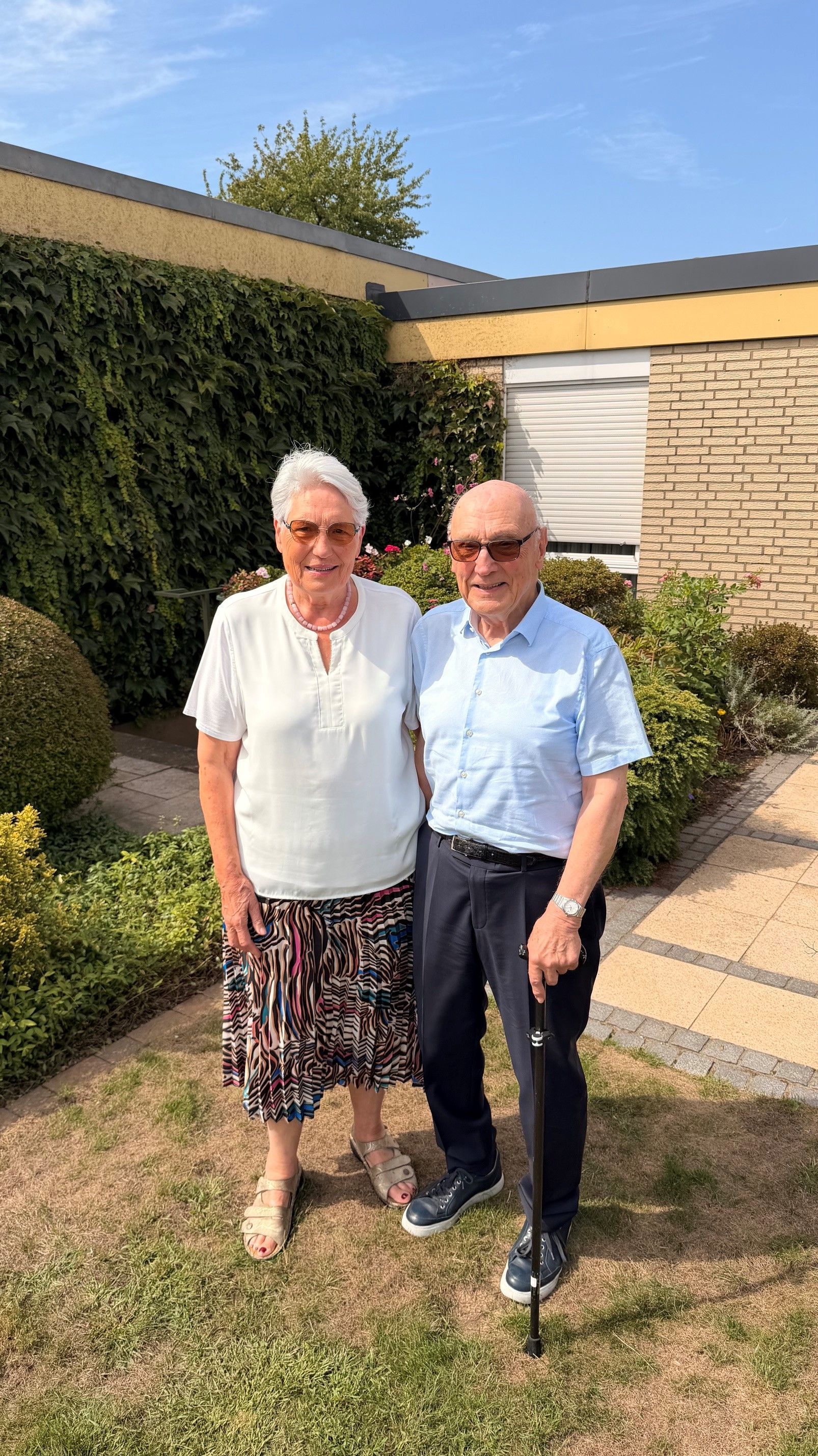 Eine Frau und ein Mann stehen vor ihrem Haus.