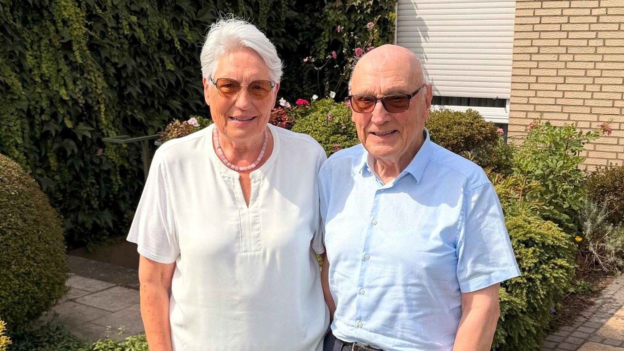 Eine Frau und ein Mann stehen vor ihrem Haus.