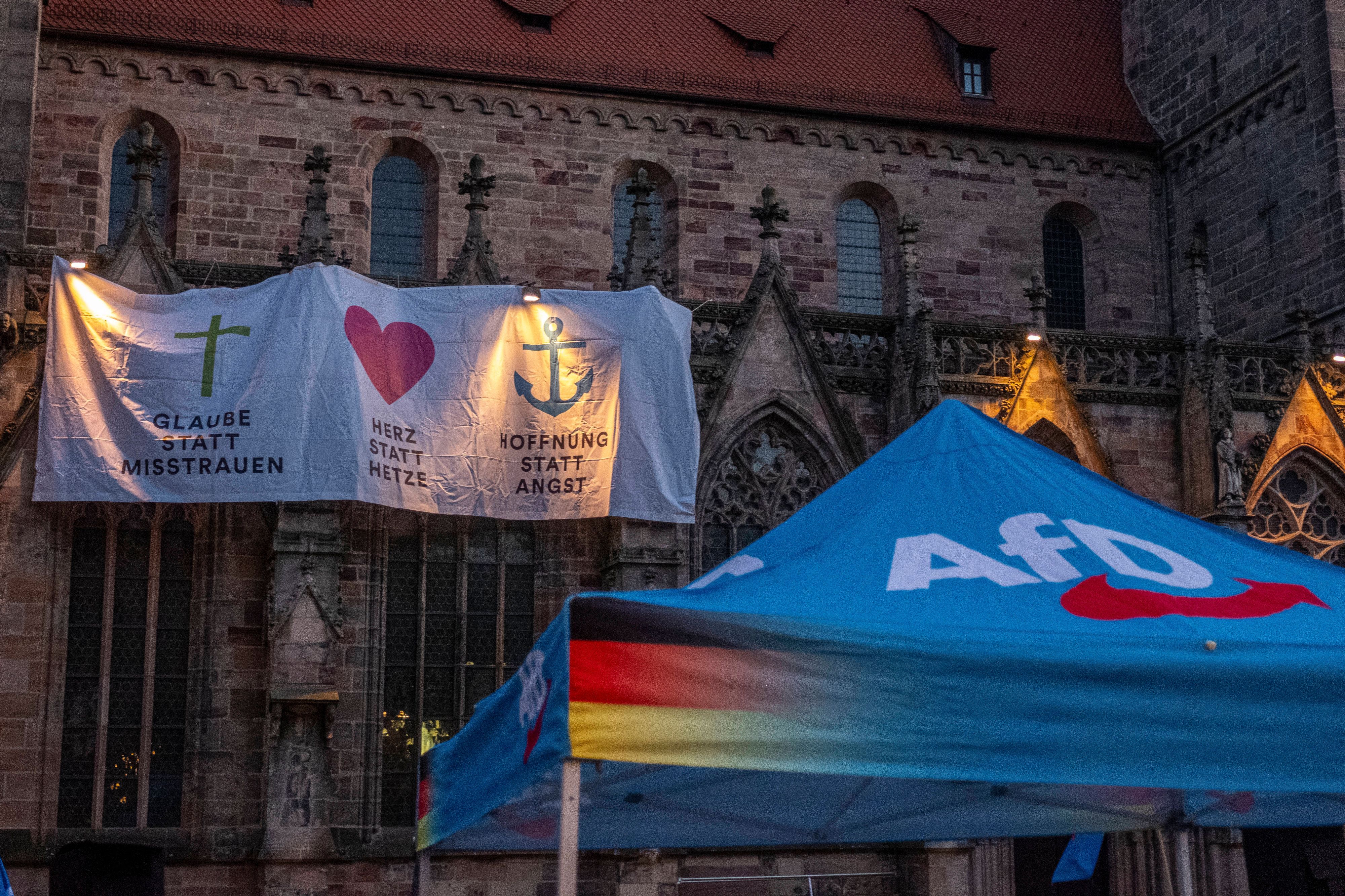 Eine Kirchengemeinde protestiert mit einem Laken am äußeren Kirchengebäude gegen eine Kundgebung der AfD.