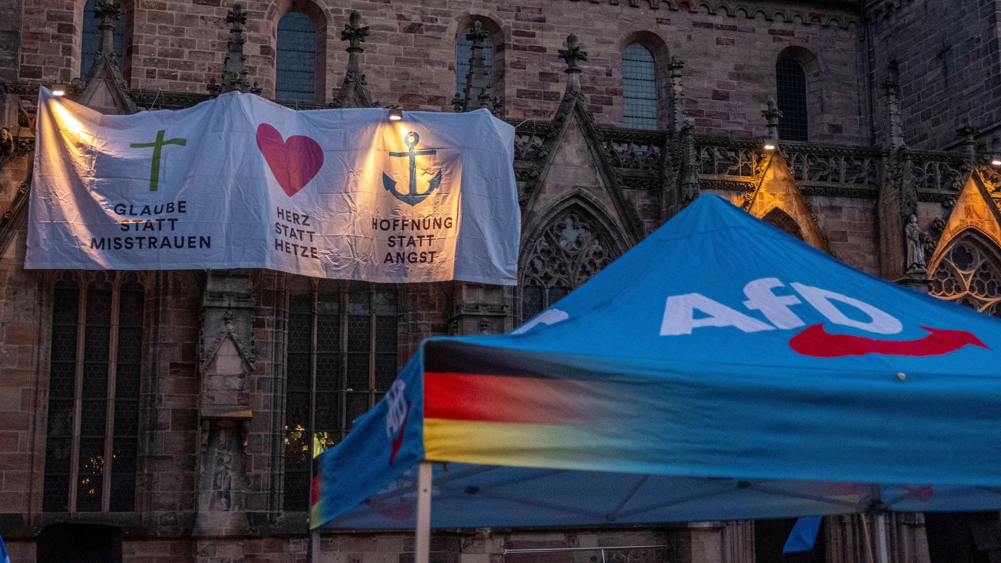 Eine Kirchengemeinde protestiert mit einem Laken am äußeren Kirchengebäude gegen eine Kundgebung der AfD.