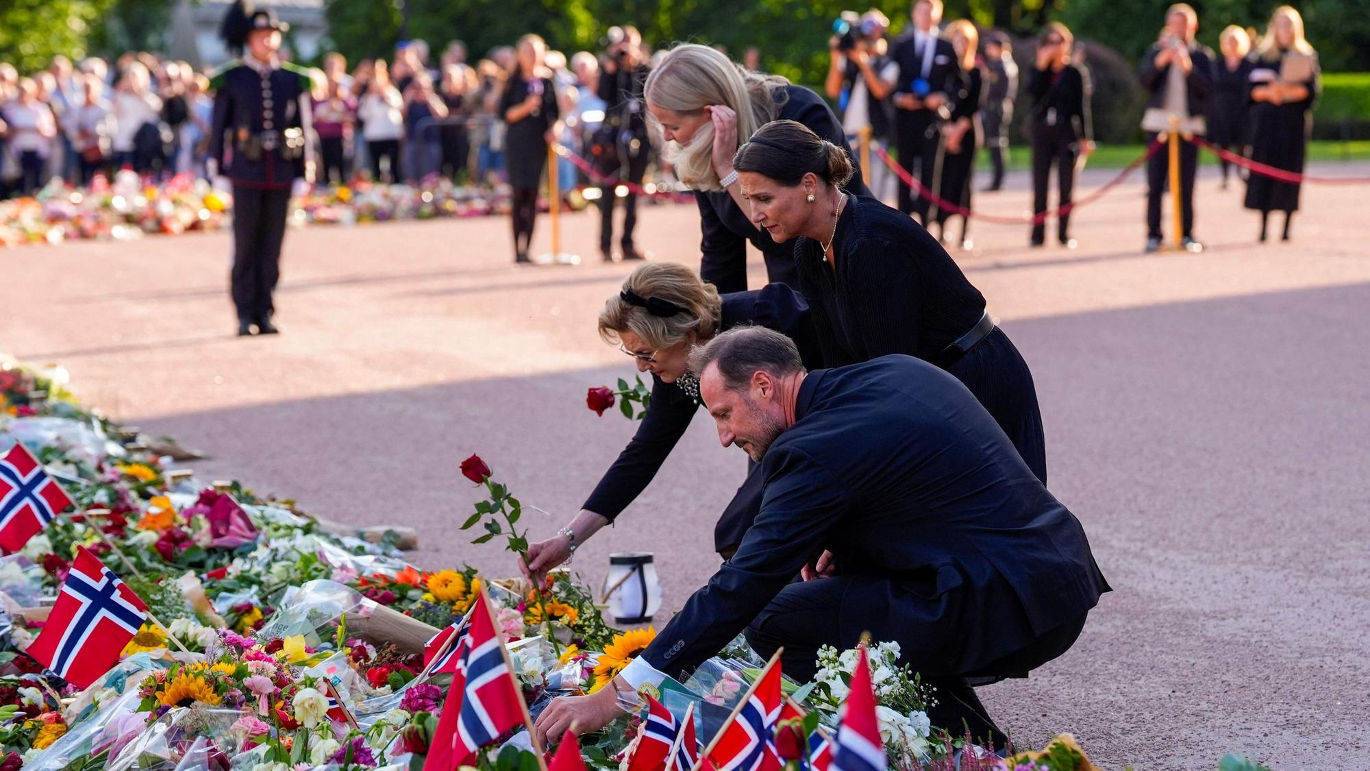 König Haakon VIII., Prinzessin Märtha Louise, Königin Sonja und Königin Mette-Marit betrachten die zahlreichen Blumen und Beileidsbekundungen der Trauernden auf dem Schlossplatz in Oslo.