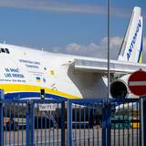 Eine ukrainische Antonow parkt am Flughafen Leipzig/Halle hinter einem Zaun auf dem Flughafengelände. Anfang August wurde eine mit Sprengstoff ausgestattete Drohne nach der Maschine gefunden. (Archivbild)