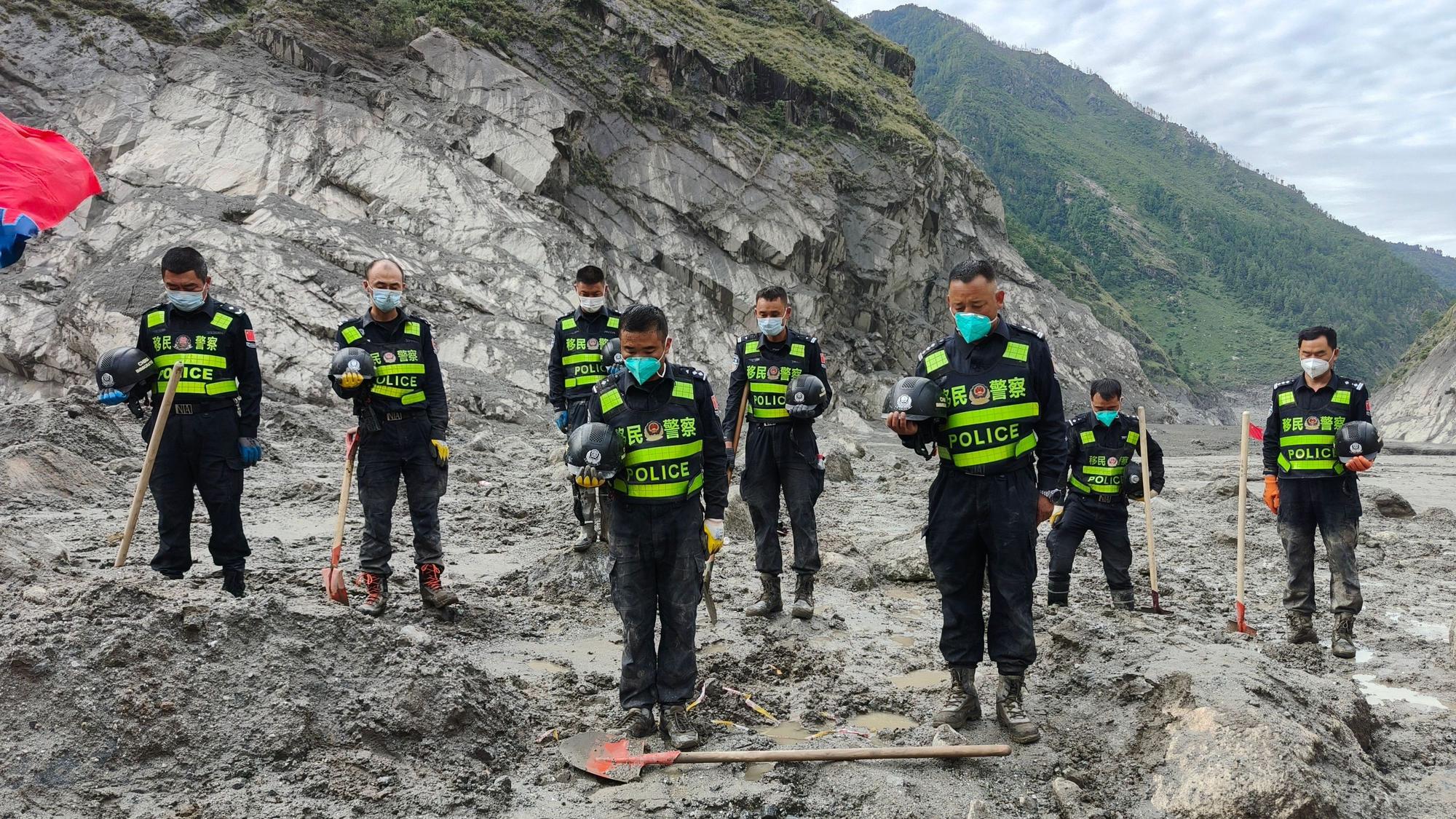 Rettungskräfte legen eine Schweigeminute für die Opfer des Schlammlawinenunglücks vom 26. August in der Nähe des Hafens von Gyirong im Kreis Gyirong in der Autonomen Region Xizang im Südwesten Chinas ein.