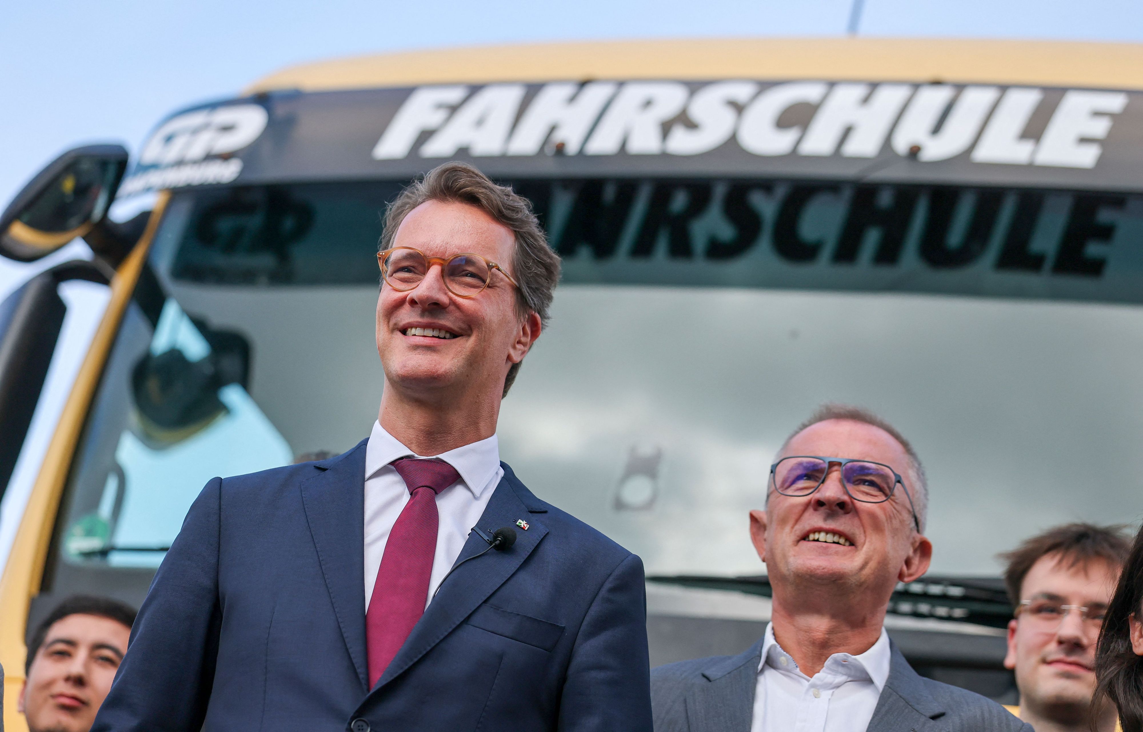 Hendrik Wüst (l, CDU), Ministerpräsident von Nordrhein-Westfalen, steht neben Marco Tullner, stellv. Landesvorsitzender CDU Sachsen-Anhalt, bei einem Unternehmensbesuch bei der Günther Papenburg AG vor einem Fahrschul-Lkw.