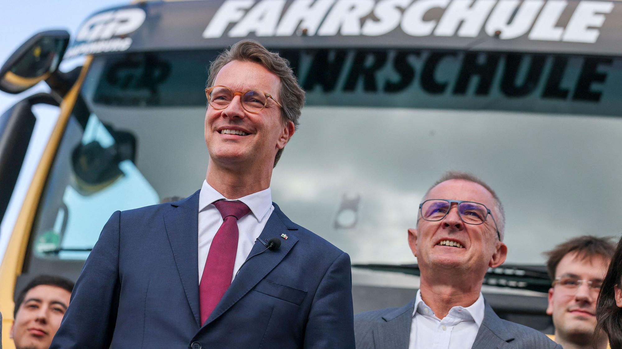 Hendrik Wüst (l, CDU), Ministerpräsident von Nordrhein-Westfalen, steht neben Marco Tullner, stellv. Landesvorsitzender CDU Sachsen-Anhalt, bei einem Unternehmensbesuch bei der Günther Papenburg AG vor einem Fahrschul-Lkw.