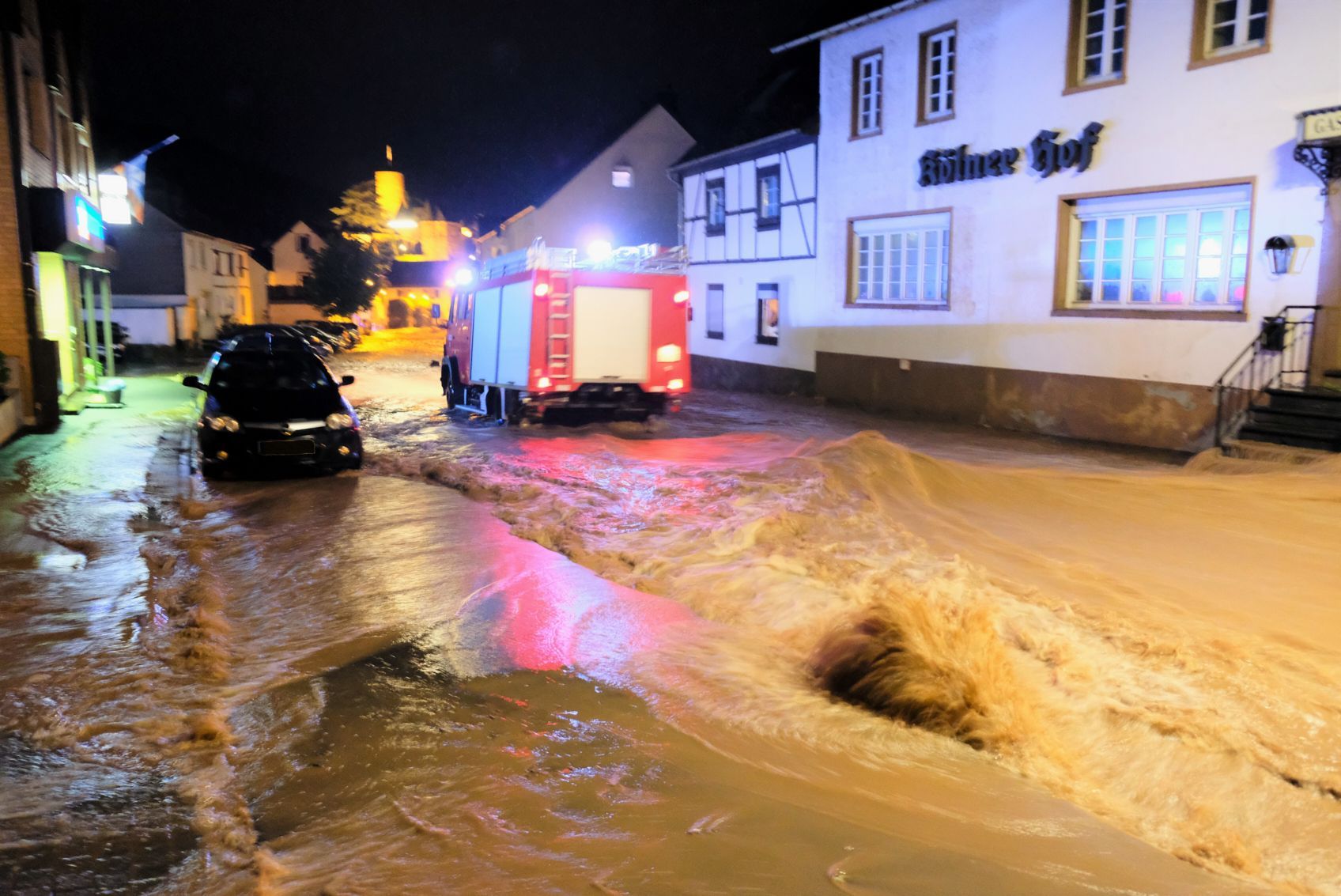 Über die Hengebachstraße schoss die Flut im Juli 2021 in die Heimbacher Innenstadt. Ein Feuerwehrfahrzeug fährt durch das Wasser.