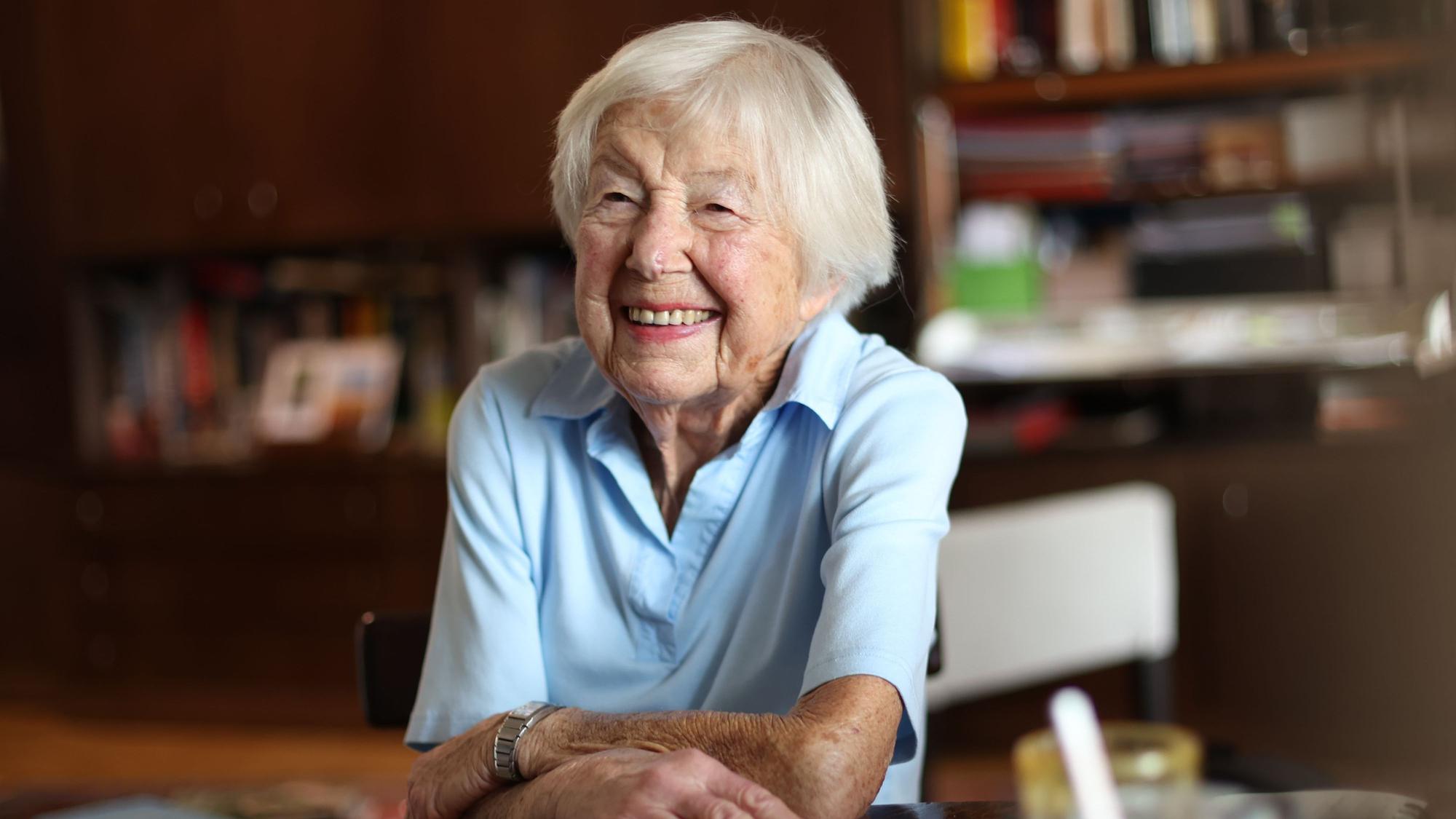 Helga Schmitt im Porträt. Sie lacht in einer Gesprächssituation in die Kamera.