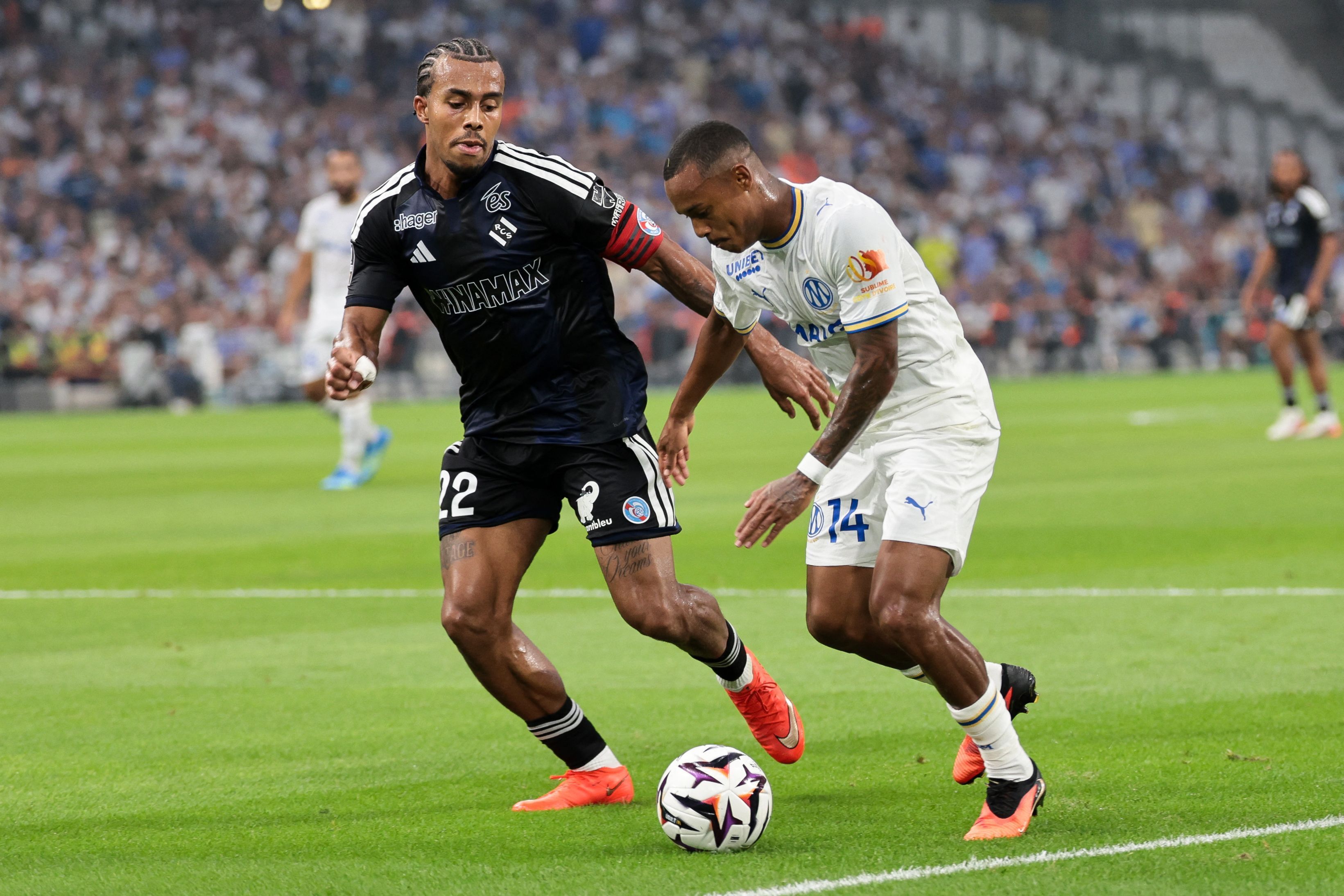 Strasbourg's Ivorian defender #22 Guela Doue (L) fights for the ball with Marseille's Brazilian forward #14 Igor Paixao during the French L1 football match between Olympique de Marseille (OM) and RC Strasbourg Alsace at the Stade Velodrome in Marseille, south-eastern France on August 21, 2026. (Photo by Pascal POCHARD-CASABIANCA / AFP)