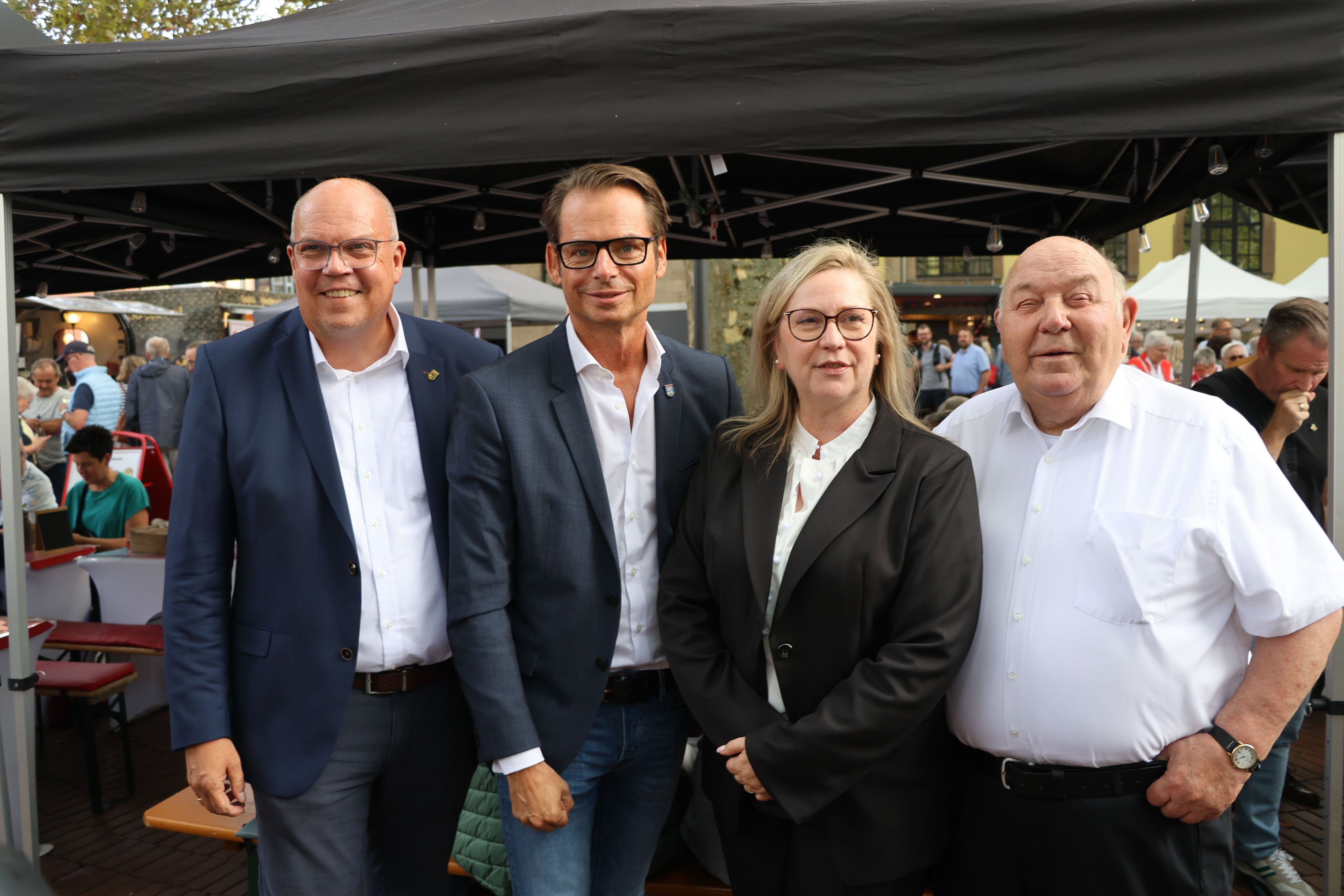 Auf dem Bild sind drei Männer und eine Frau zu sehen.