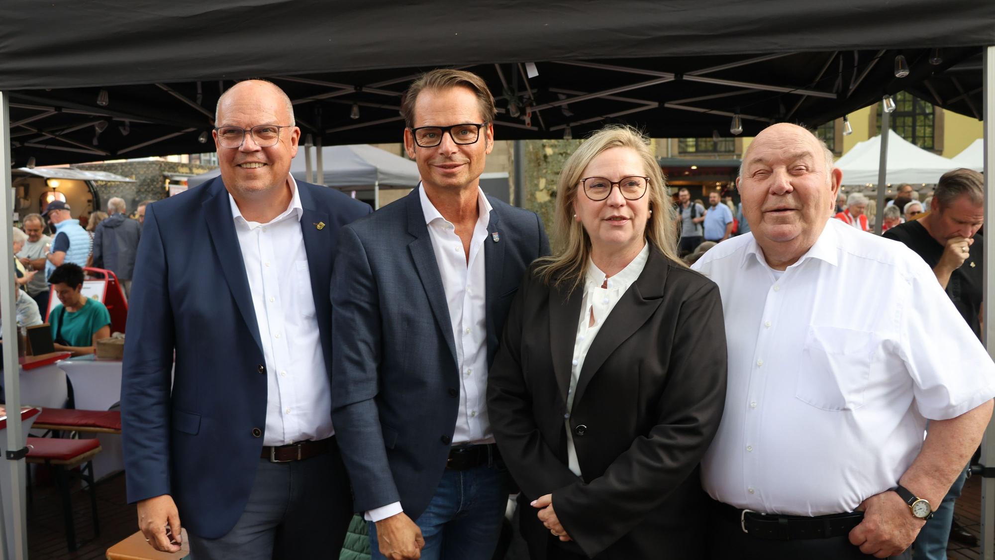 Auf dem Bild sind drei Männer und eine Frau zu sehen.