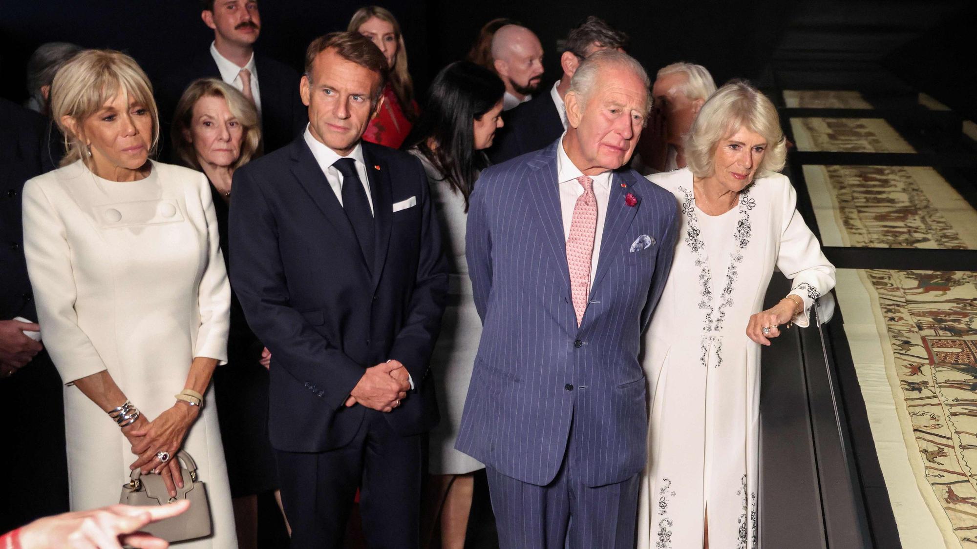 Emmanuel Macron, König Charles III. und Königin Camilla betrachten bei einer Vorbesichtigung im British Museum Teile des historischen Teppichs von Bayeux.