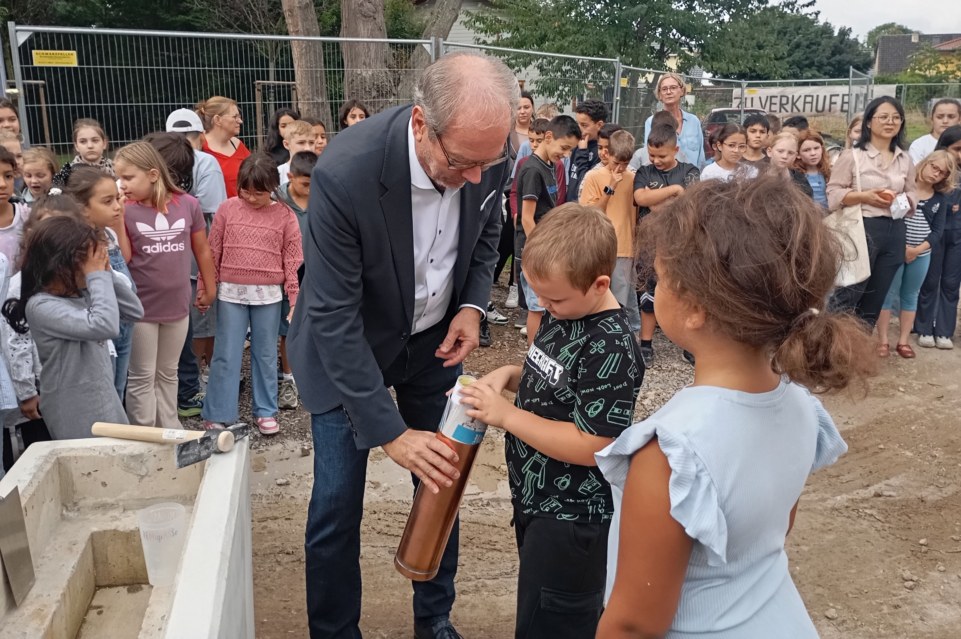 Zu sehen sind Bergheims Bürgermeister Volker Mießeler und zwei Kinder.