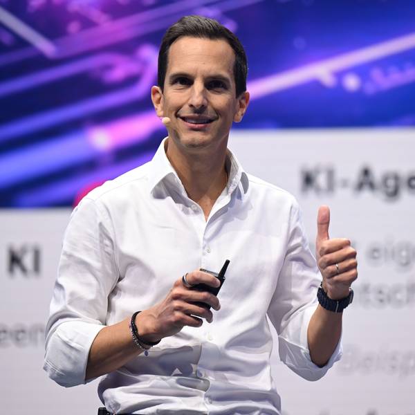 Rodrigo Diehl, steht im weißen Hemd und ohne Krawatte auf der Digitalmesse Digital X 2025 lächelnd auf einer Bühne und spricht zum Publikum