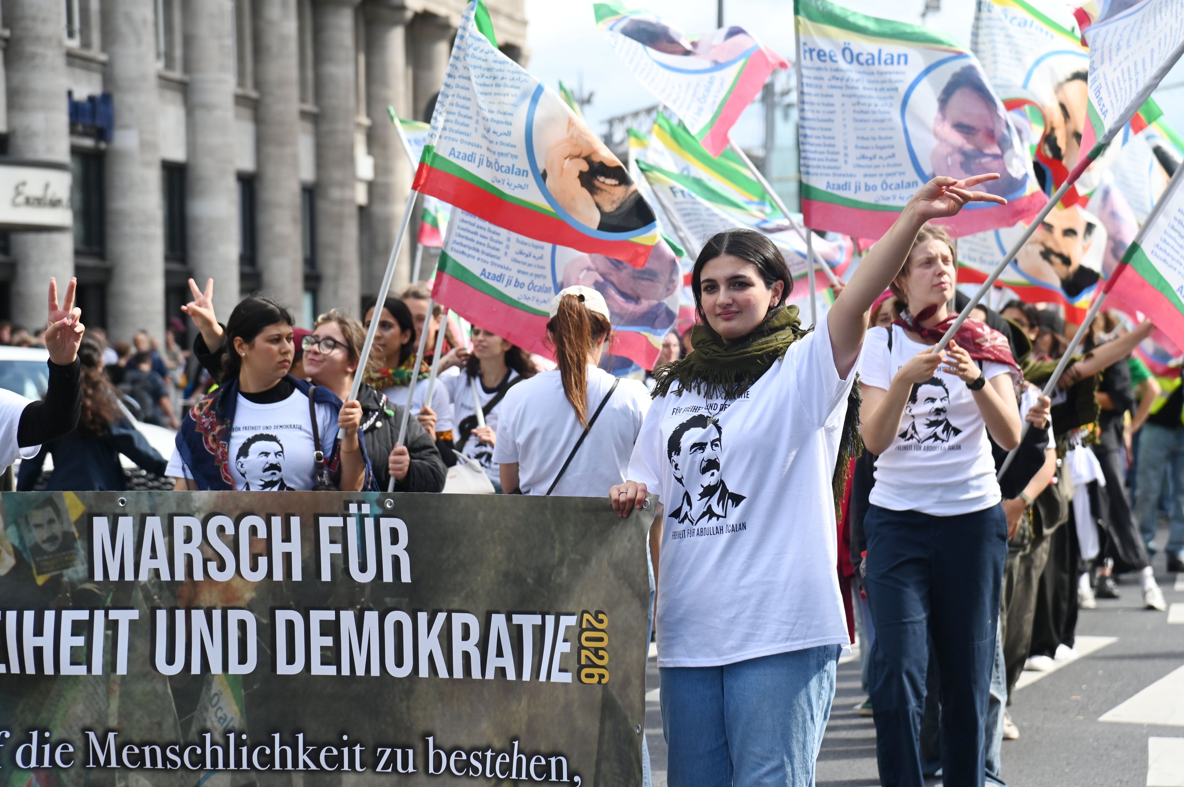 Bestückt mit zahlreichen Flaggen und Bannern ziehen die Teilnehmden des „Langen Marsch für Freiheit und Demokratie“ durch Köln.