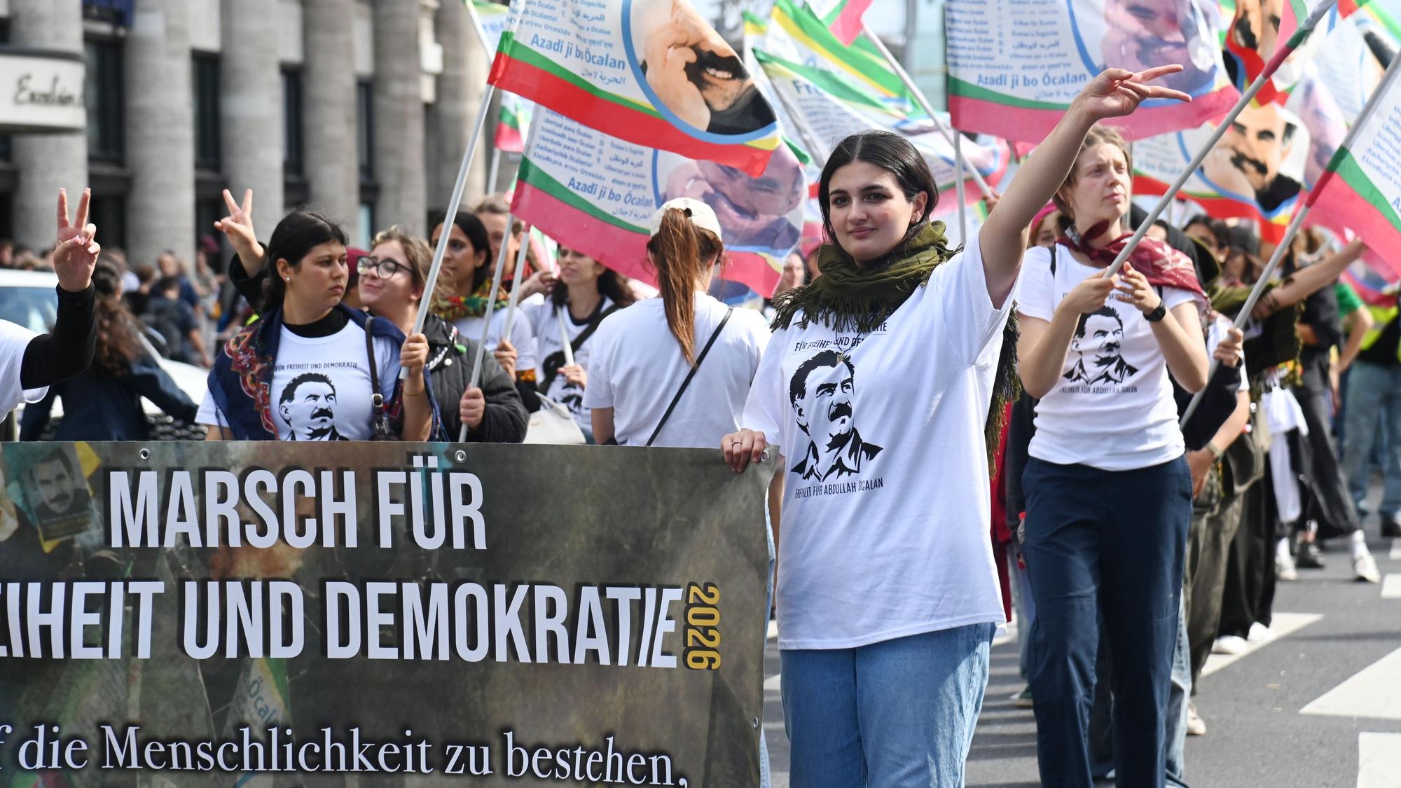 Bestückt mit zahlreichen Flaggen und Bannern ziehen die Teilnehmden des „Langen Marsch für Freiheit und Demokratie“ durch Köln.