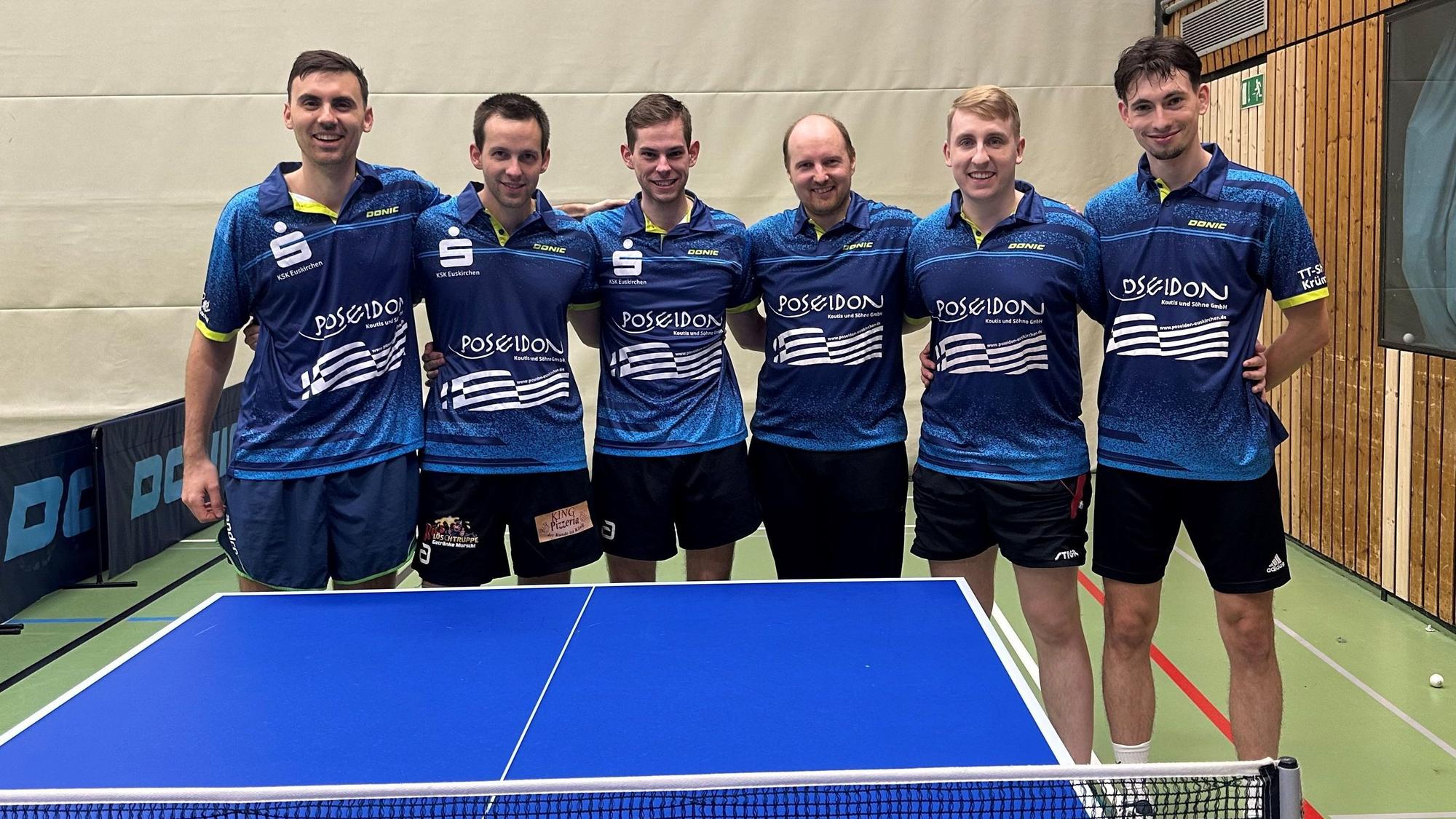 Sechs Tischtennisspieler stehen Arm in Arm hinter einer Platte.