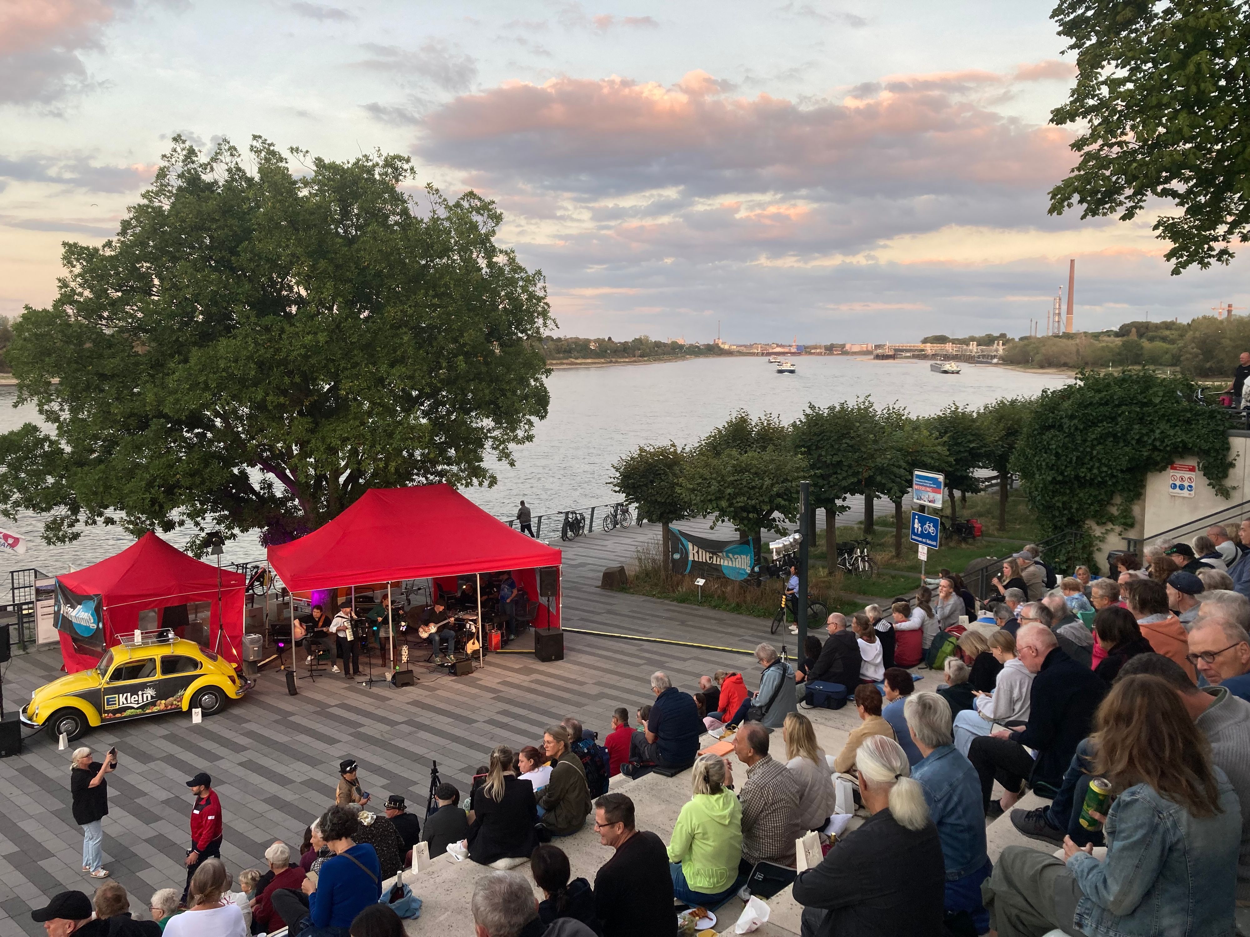Auf dem Foto sind die Besucher der Wesselinger Lichter auf der Rheintreppe, der Rhein und die Bühne zu sehen.