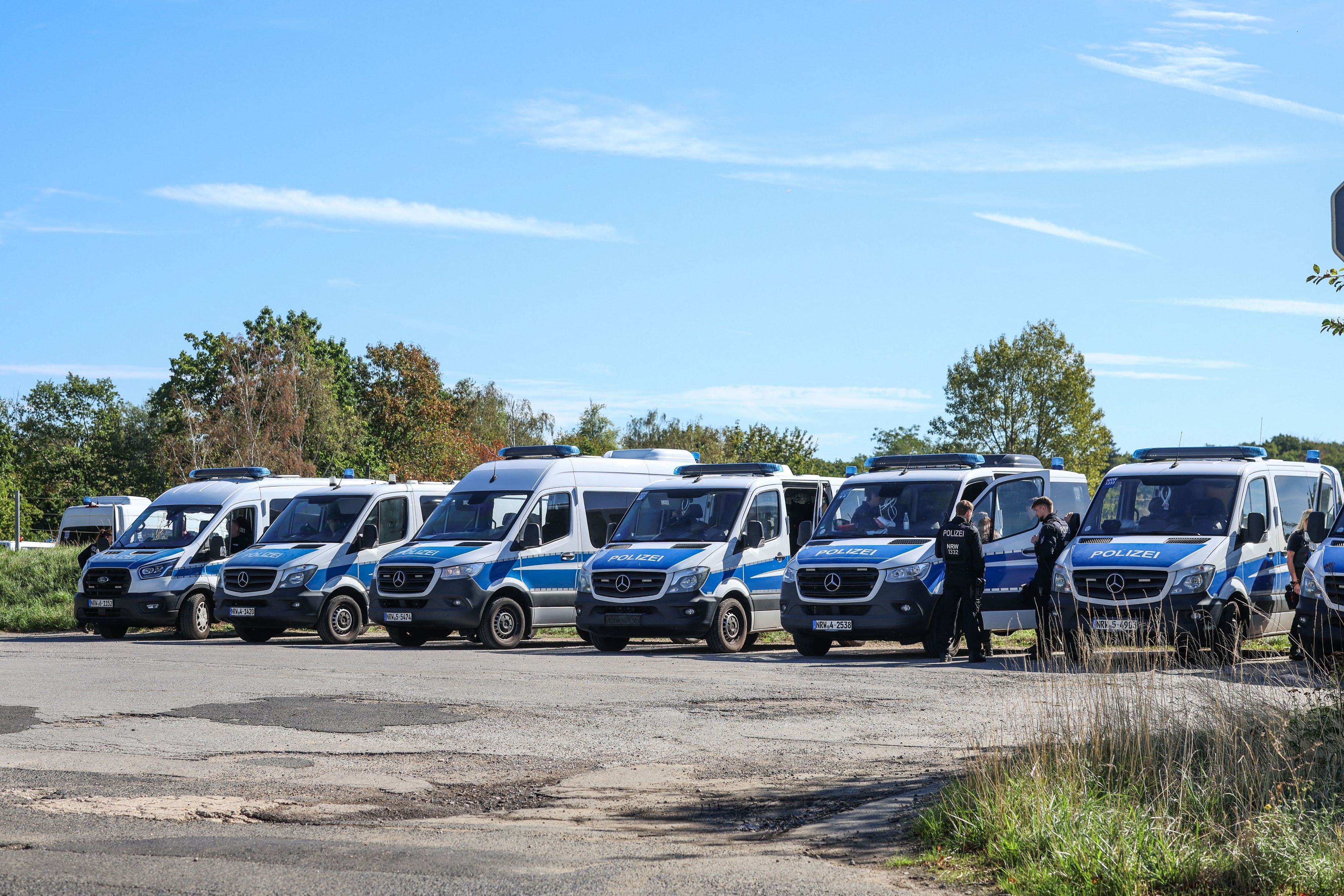 Zahlreiche Polizeikräfte sammeln sich für einen Großeinsatz auf einem Parkplatz in der Nähe des Hambacher Forst.