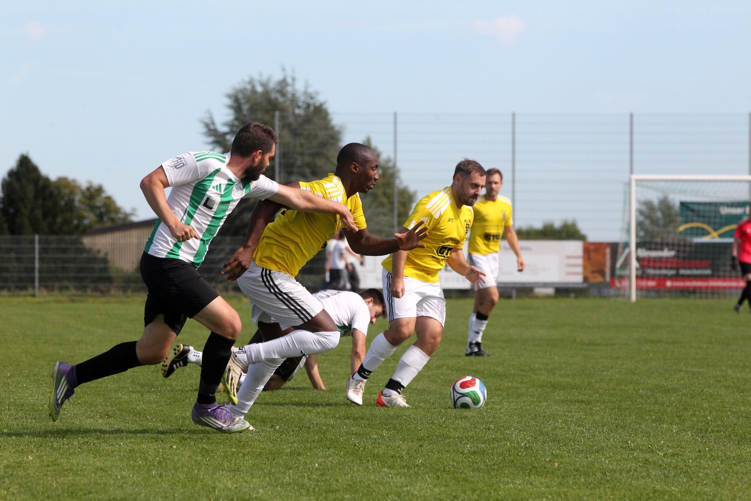 Ein Golbacher Spieler am Ball, neben ihm startet ein Mitspieler, der von einem Gegenspieler aufgehalten werden soll.
