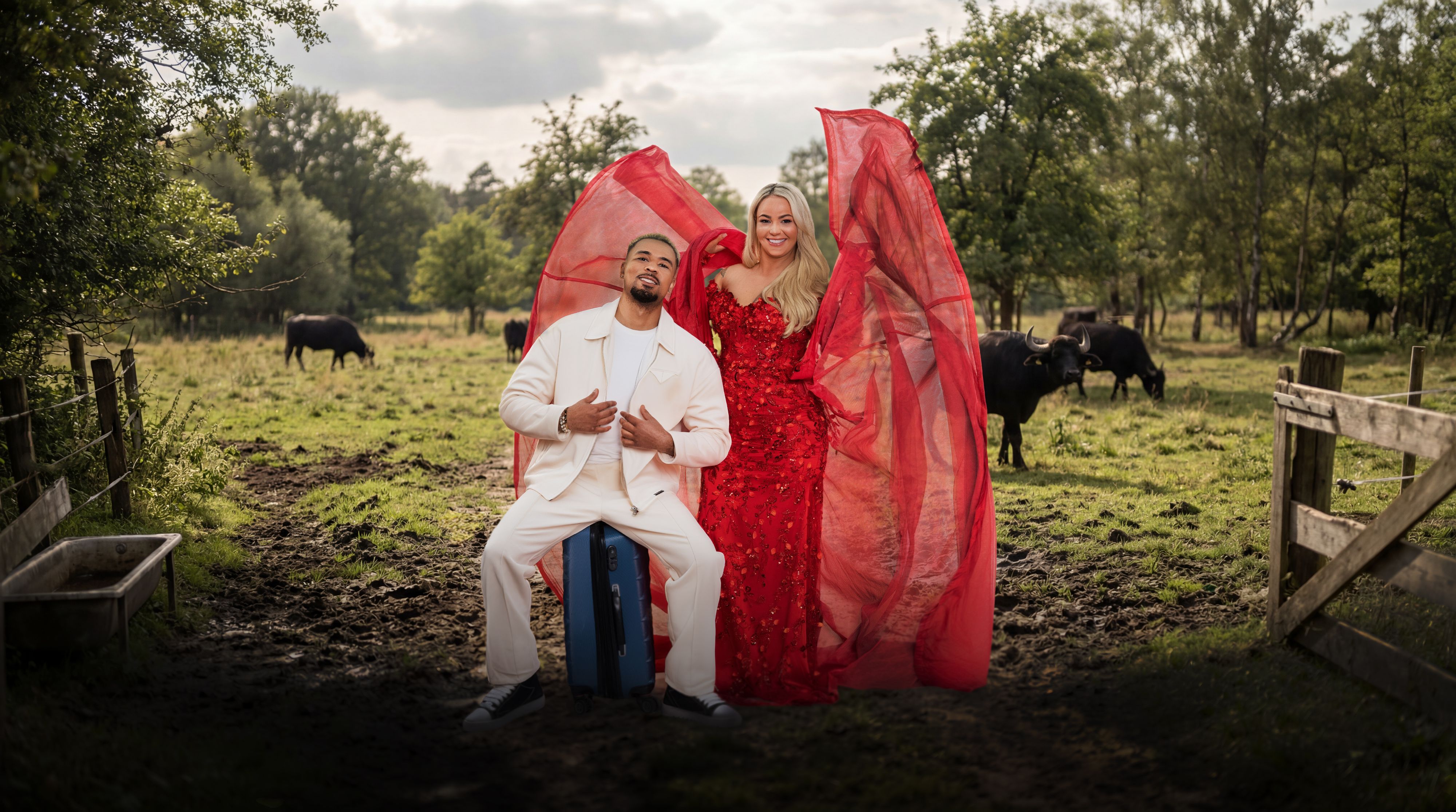 Anita Latifi, die ihr rotes Kleid ausbreitet und ihr Ehemann Fabrice, der auf seinem Koffer sitzt