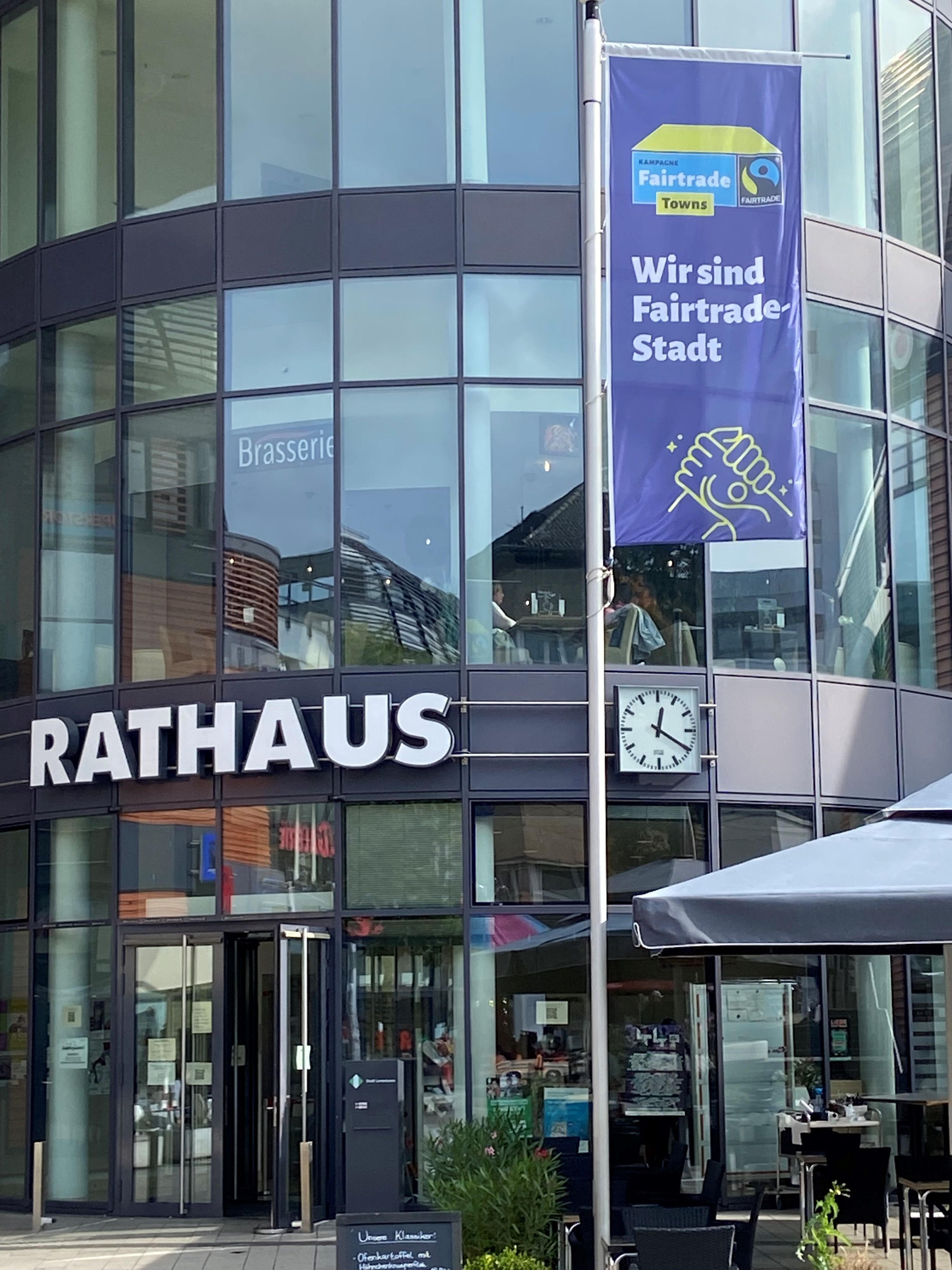 Die Fair-Trade-Fahne  wird zur Aktionswoche vor dem Rathaus gehisst.