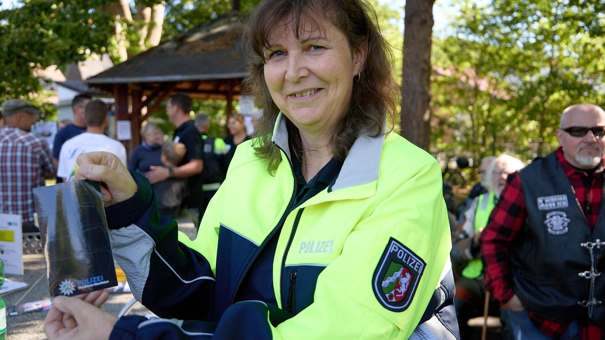 Eine Polizistin hält eine schwarze Reflektorfolie in der Hand.