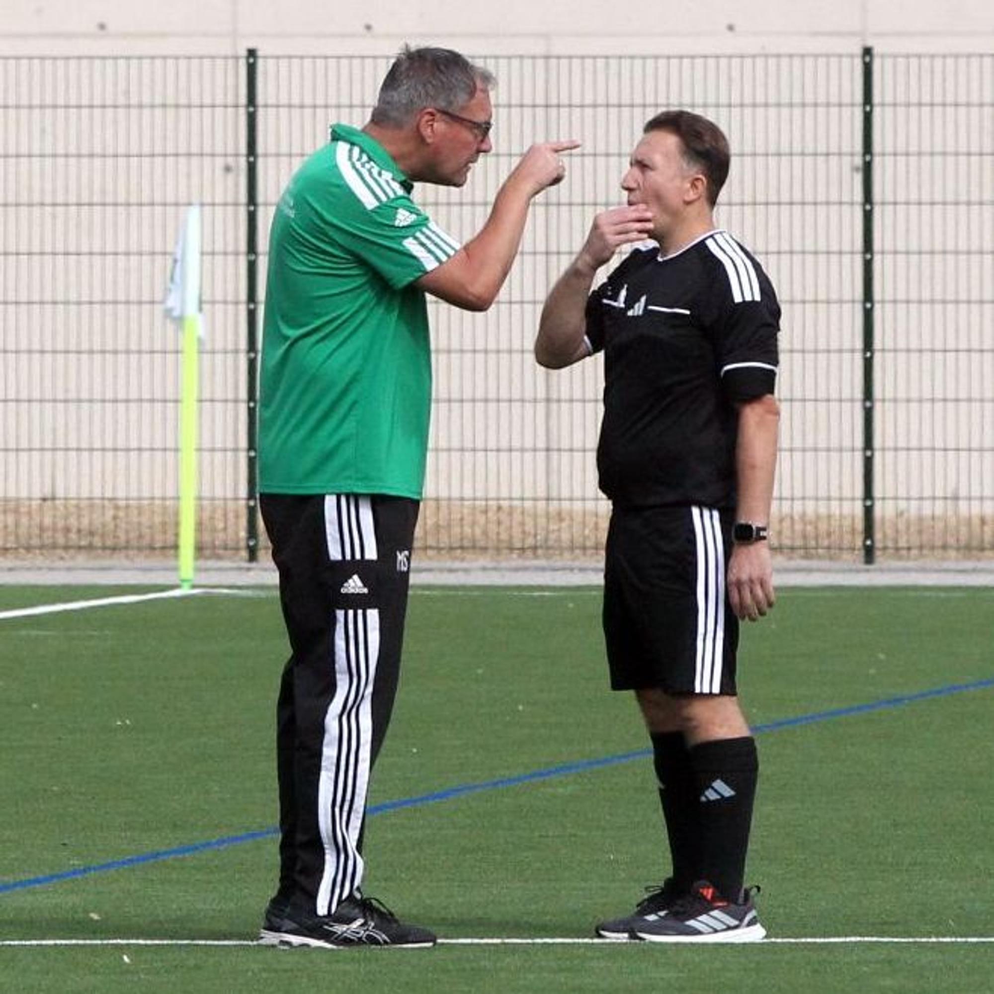 Sötenichs Trainer Markus Sabel diskutiert gestikulierend mit dem Schiedsrichter, der sich ins Gesicht fasst.