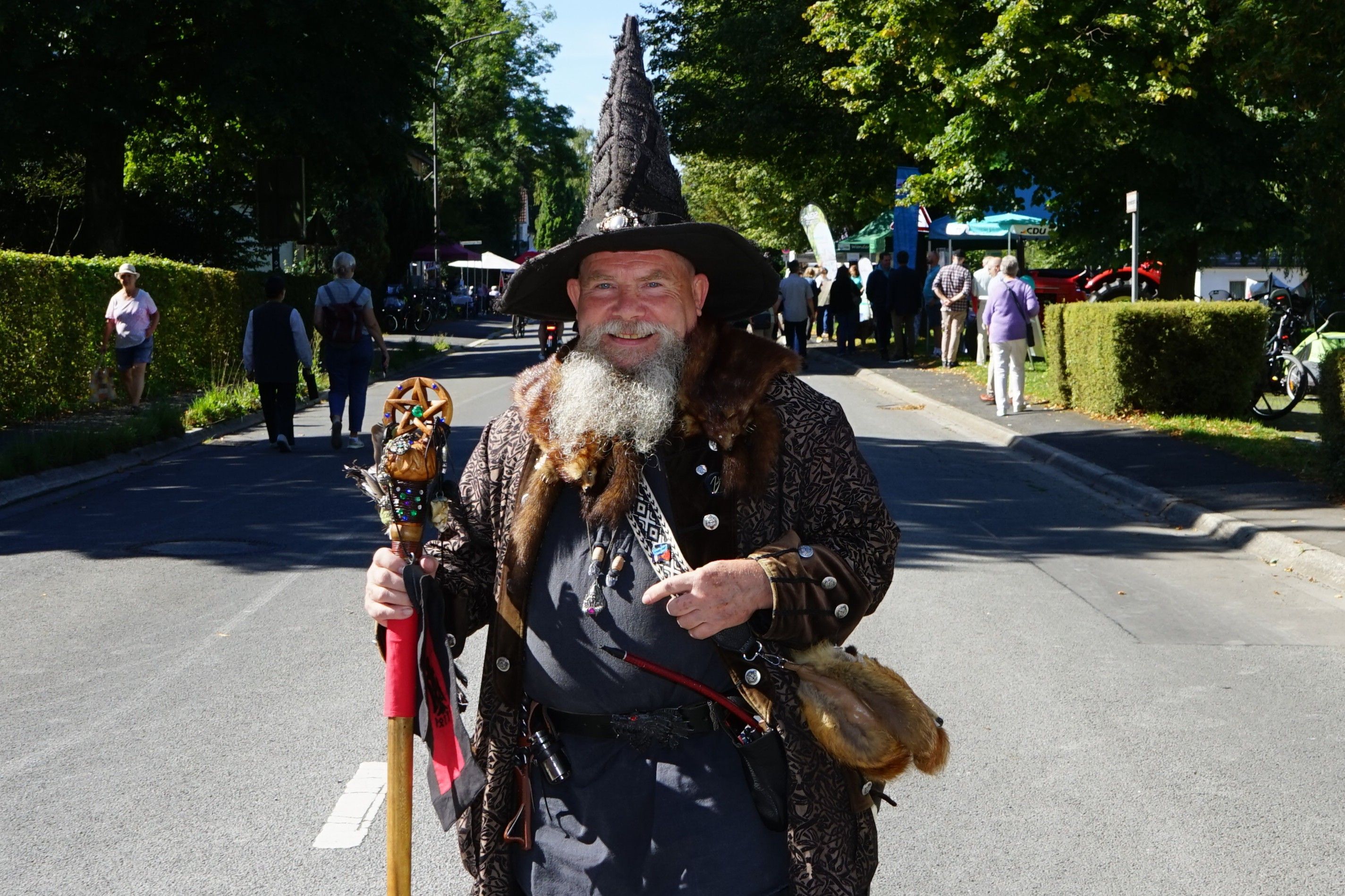 Zauberer Merlin steht auf der Straße in Herrenstrunden.