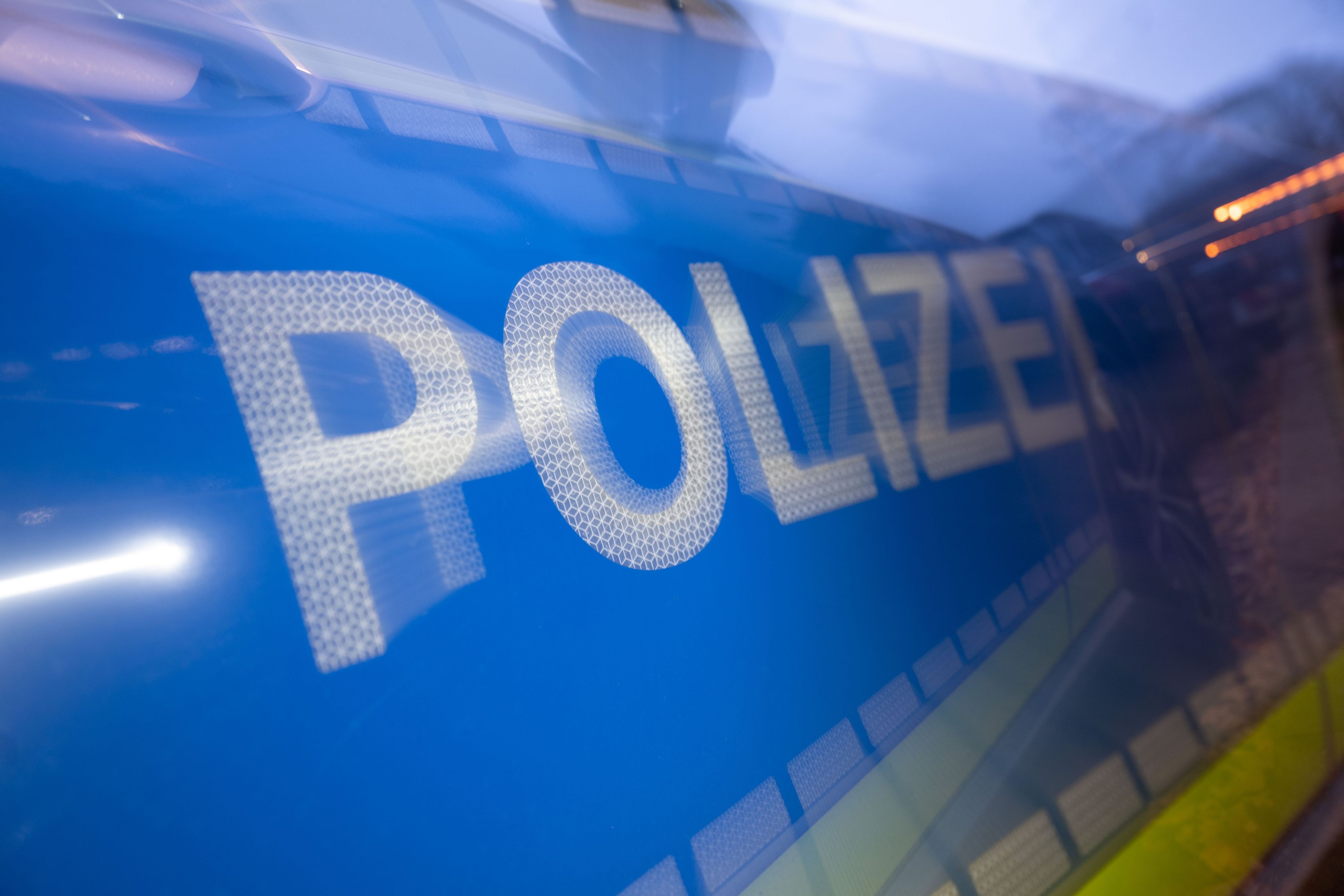 Das Wort Polizei ist im Rahmen eines Fototermins auf der Karosserie eines Polizeifahrzeugs zu sehen.