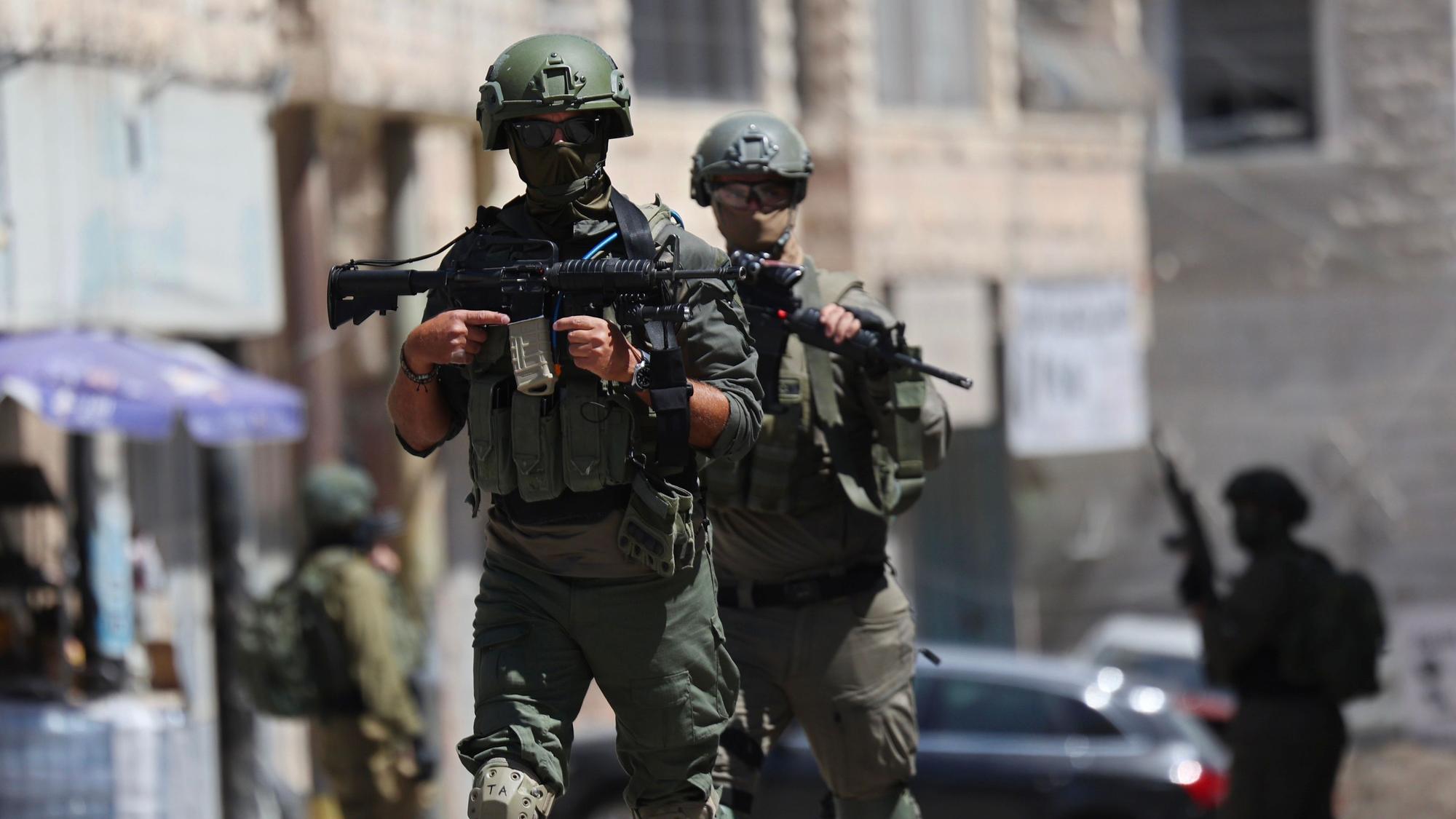 Angehörige der israelischen Streitkräfte kontrollieren während einer Militärrazzia in der Stadt Anata im Westjordanland eine Straße.