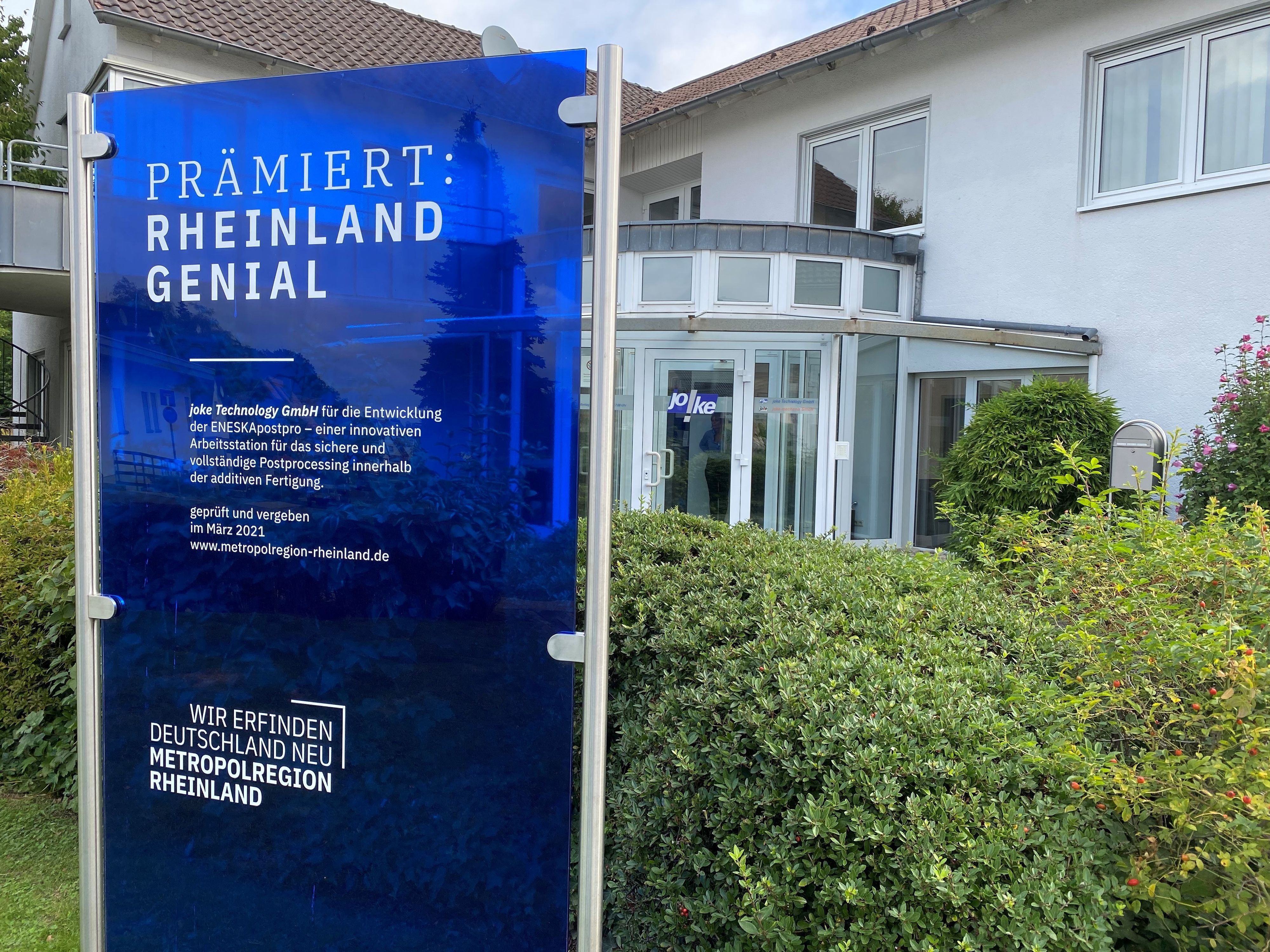 Eine Preisverleihungstafel steht vor dem Unternehmen Joke in Bergisch Gladbach-Herkenrath.