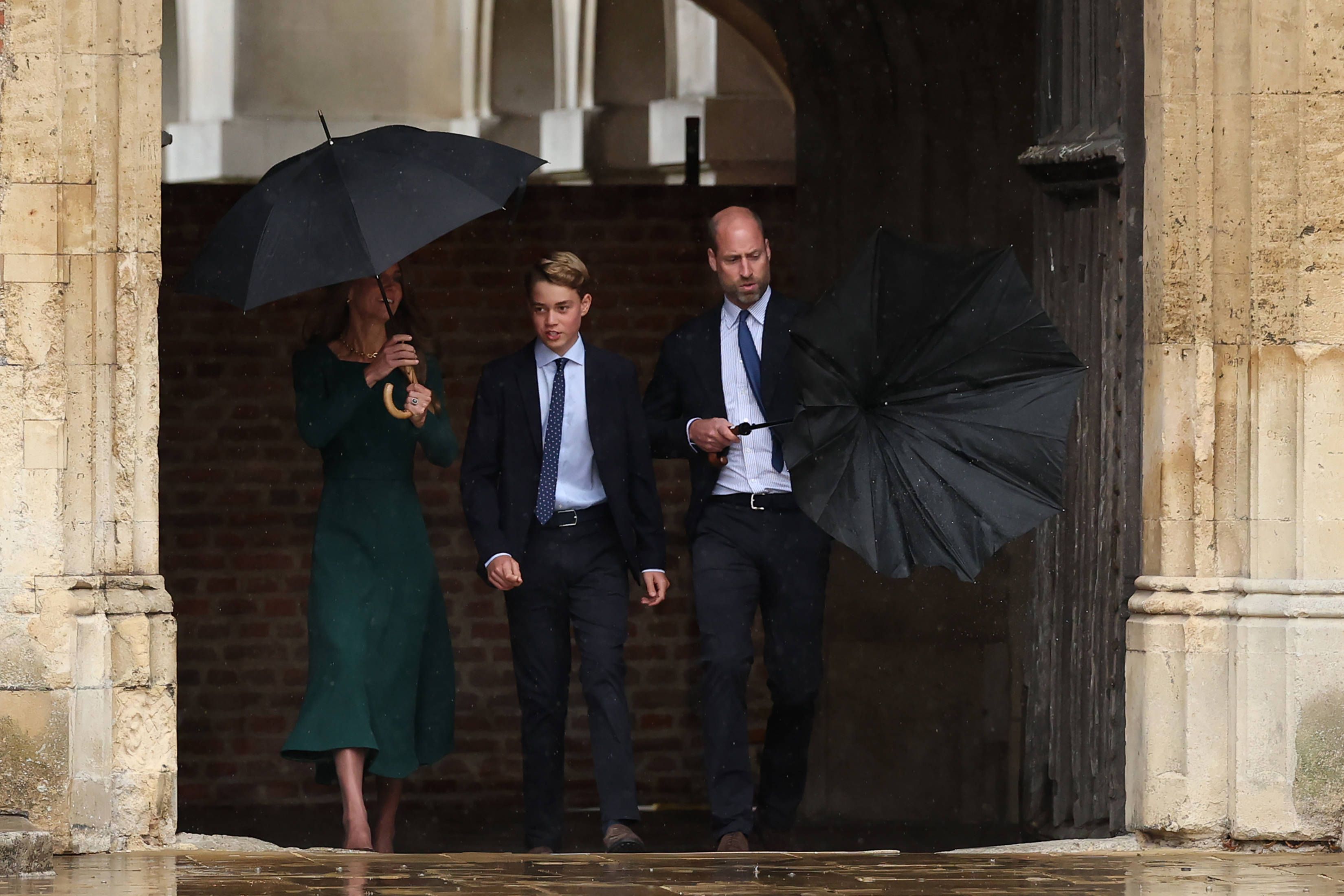 Prinz William (r.) müht sich mit seinem Regenschirm ab, während er gemeinsam mit Prinzessin Kate (l.) den 13-jährigen Prinz George (M.) zu dessen erstem Schultag am Eton College begleitet.